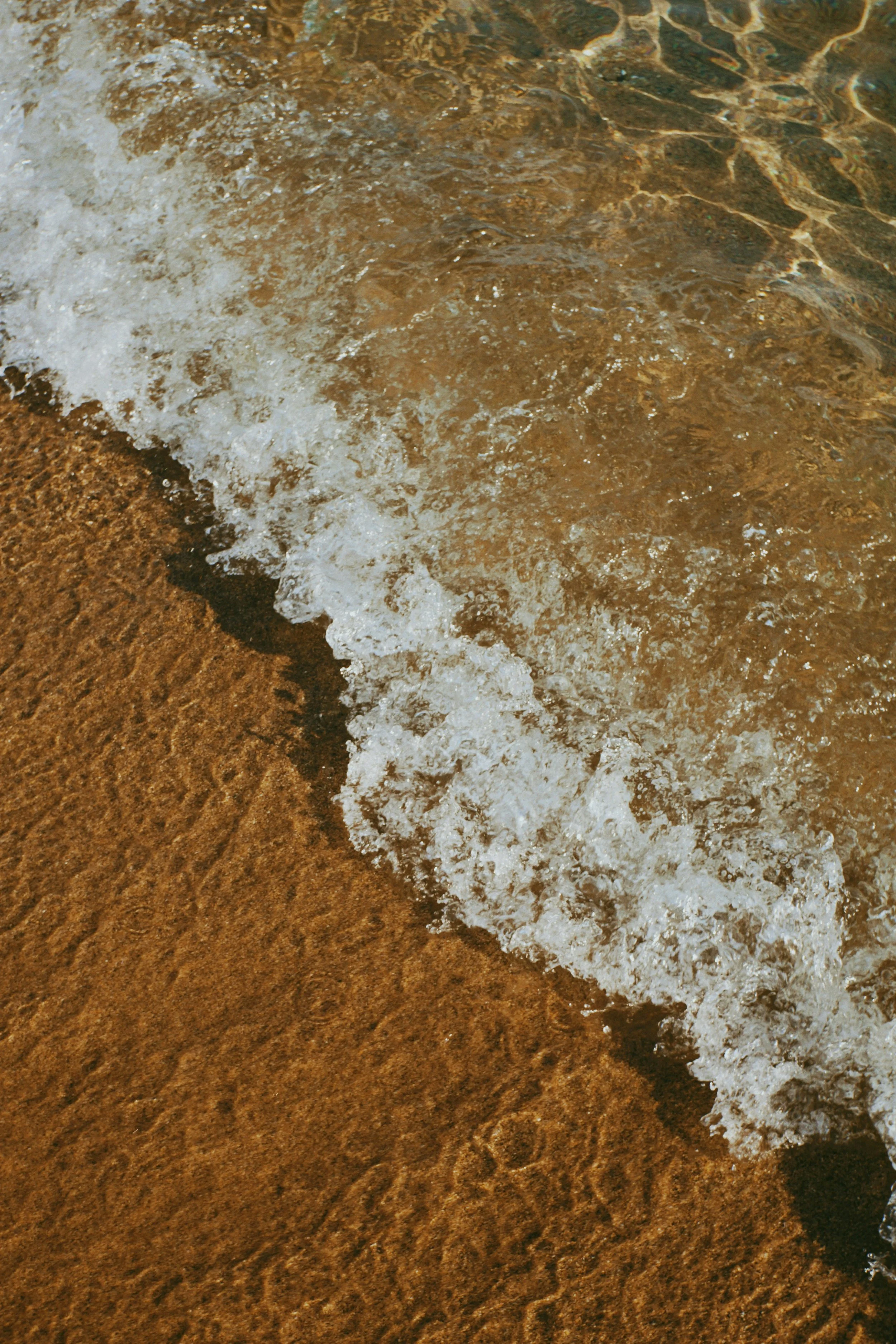 Powerful ocean waves crashing against the shoreline under an open sky, capturing movement, intensity, and the raw rhythm of nature