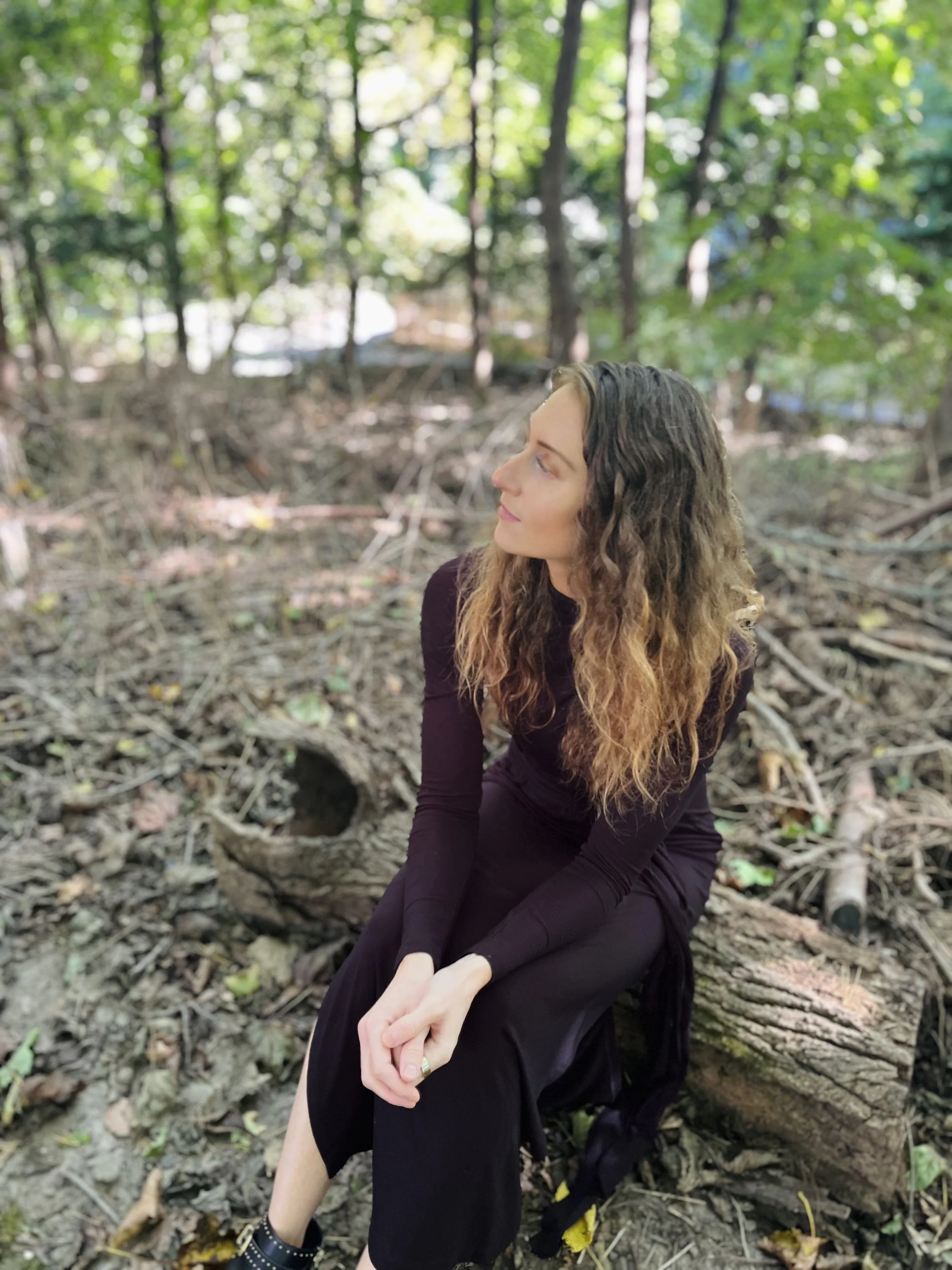Licensed holistic therapist seated in nature, representing a collaborative and trauma-informed approach to psychotherapy