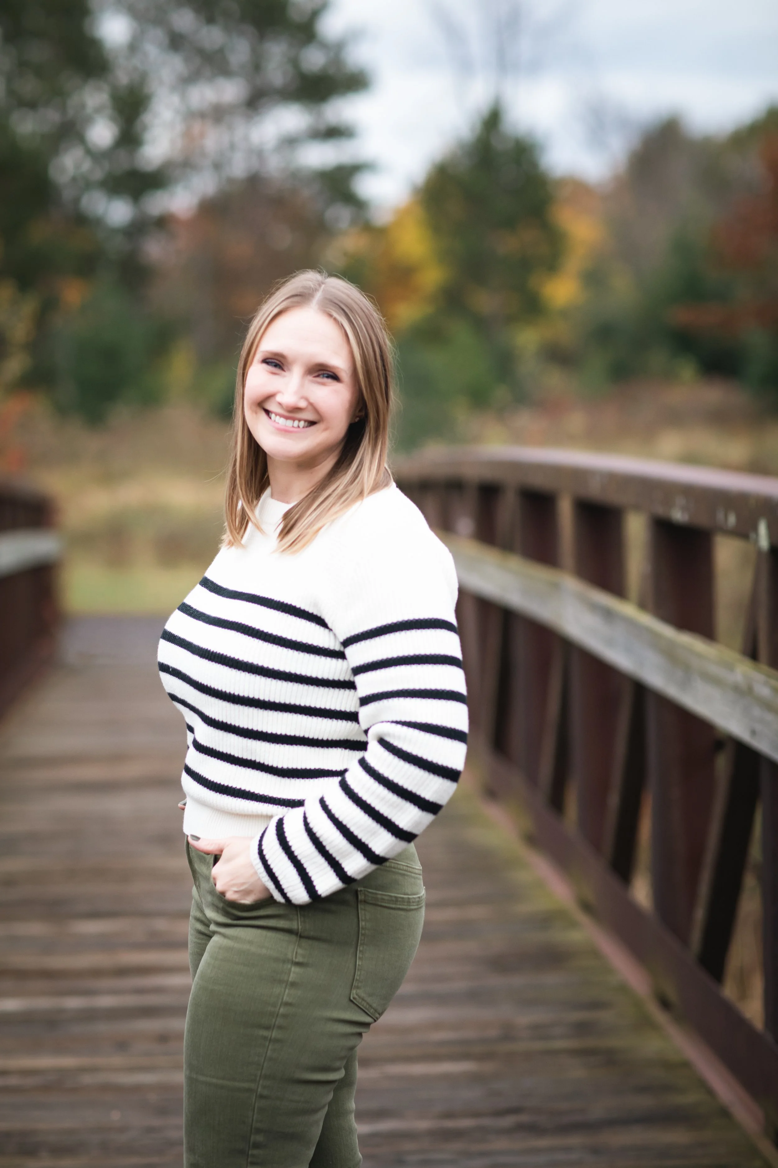 Photo of Jennifer Hahn standing on a bridge. Photo by Sunlit Photography, 2025.