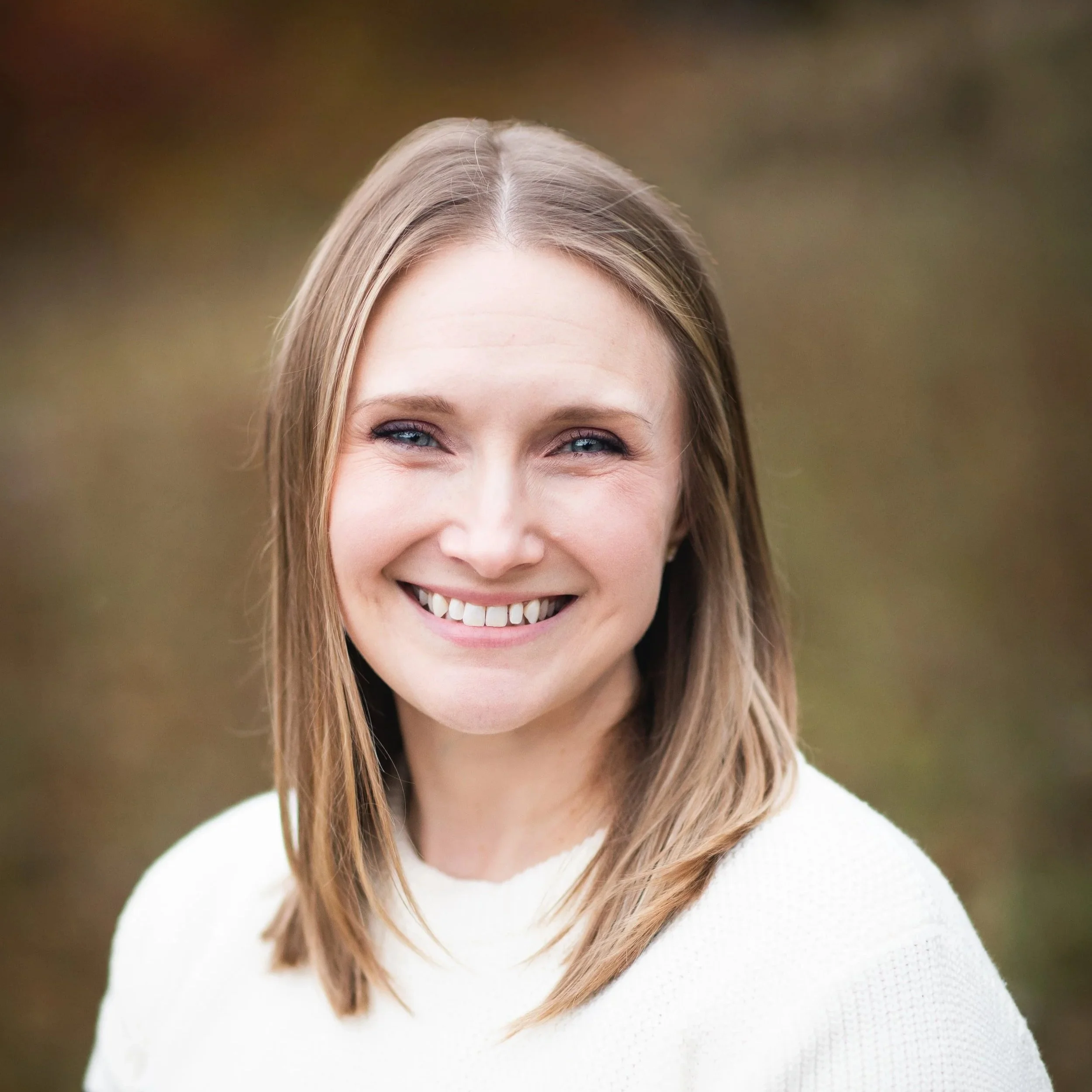 Headshot of Jennifer Hahn, pale skin, light brown hair, white sweater. Photo by Sunlit Photography, 2025.