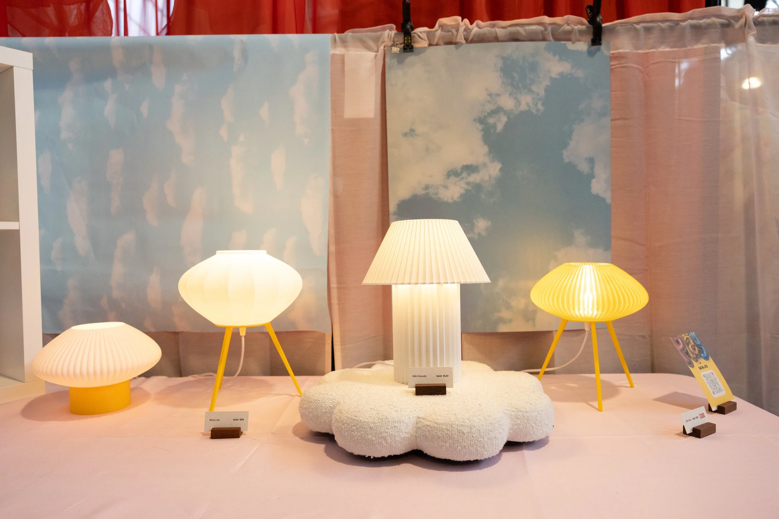 Various sized lamps displayed in a booth.