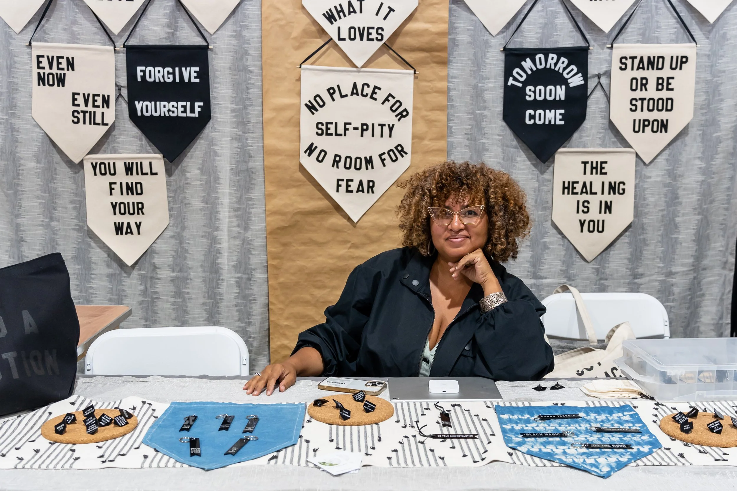 Woman sitting at a letterpress decor booth.