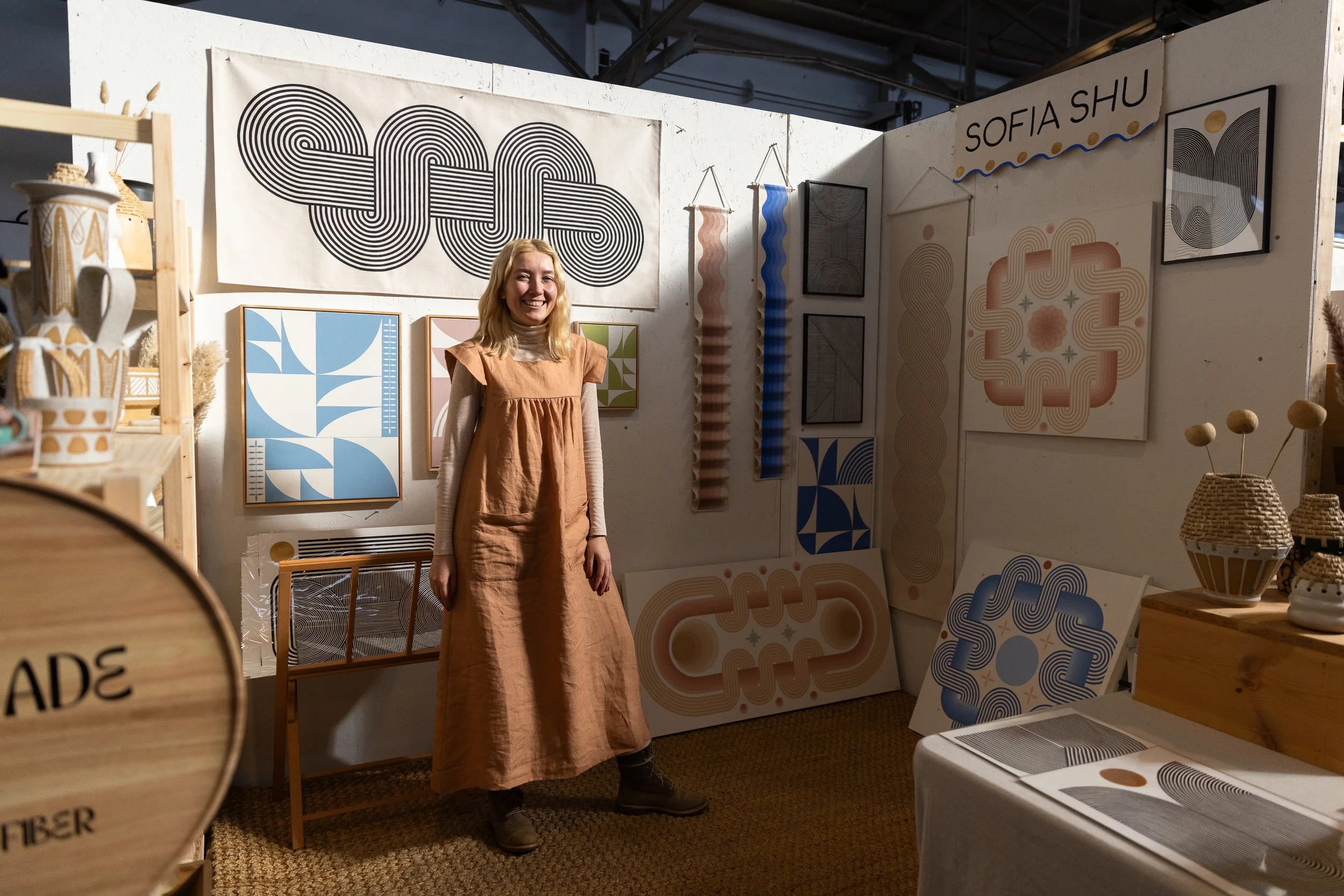 Woman standing in front of various block print artwork.