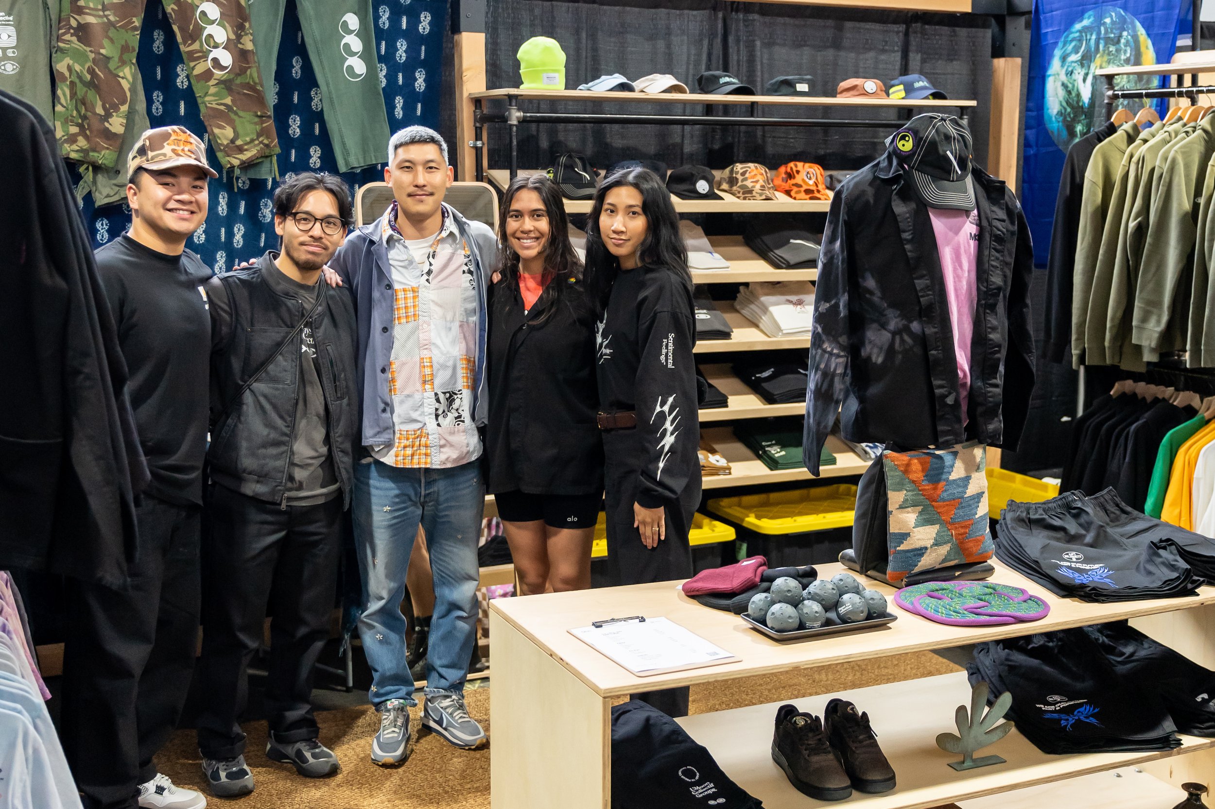 Group of people posing in a streetwear clothing booth.