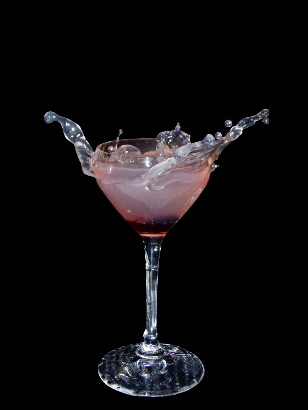 Last word cocktail splashing from a martini glass in a dramatic action shot