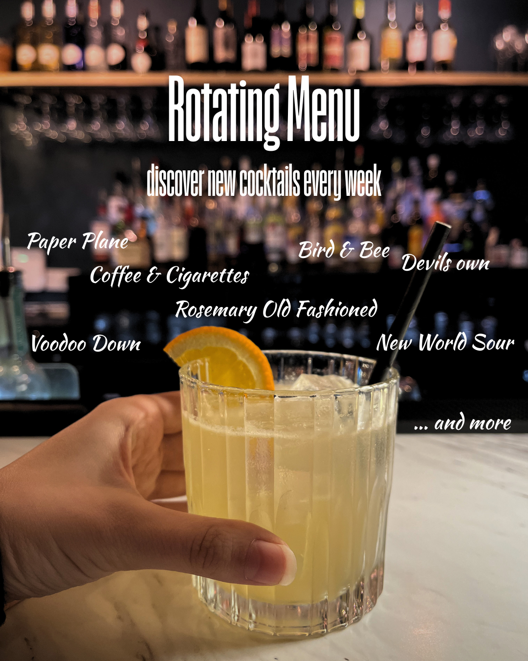 A hand holding a glass of lemonade with a lemon wedge garnish, with a bar in the background. The image features a rotating cocktail menu with various drink names listed over the image. The picture is at JoJo's Cocktail & Pizza Bar, Cowley, Oxford.