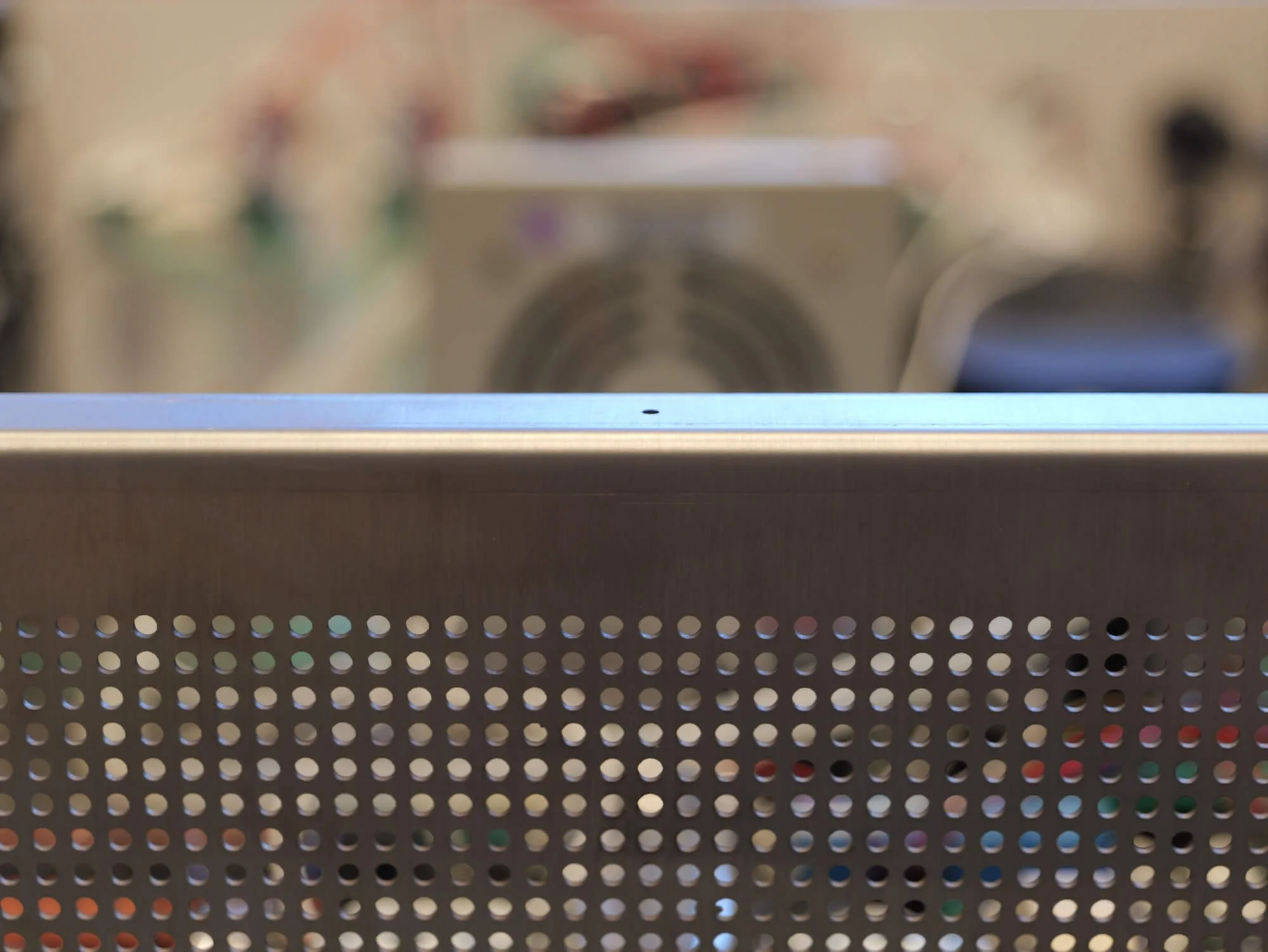 A view of the side vents and a single screw hole in the stainless steel sheet unit case