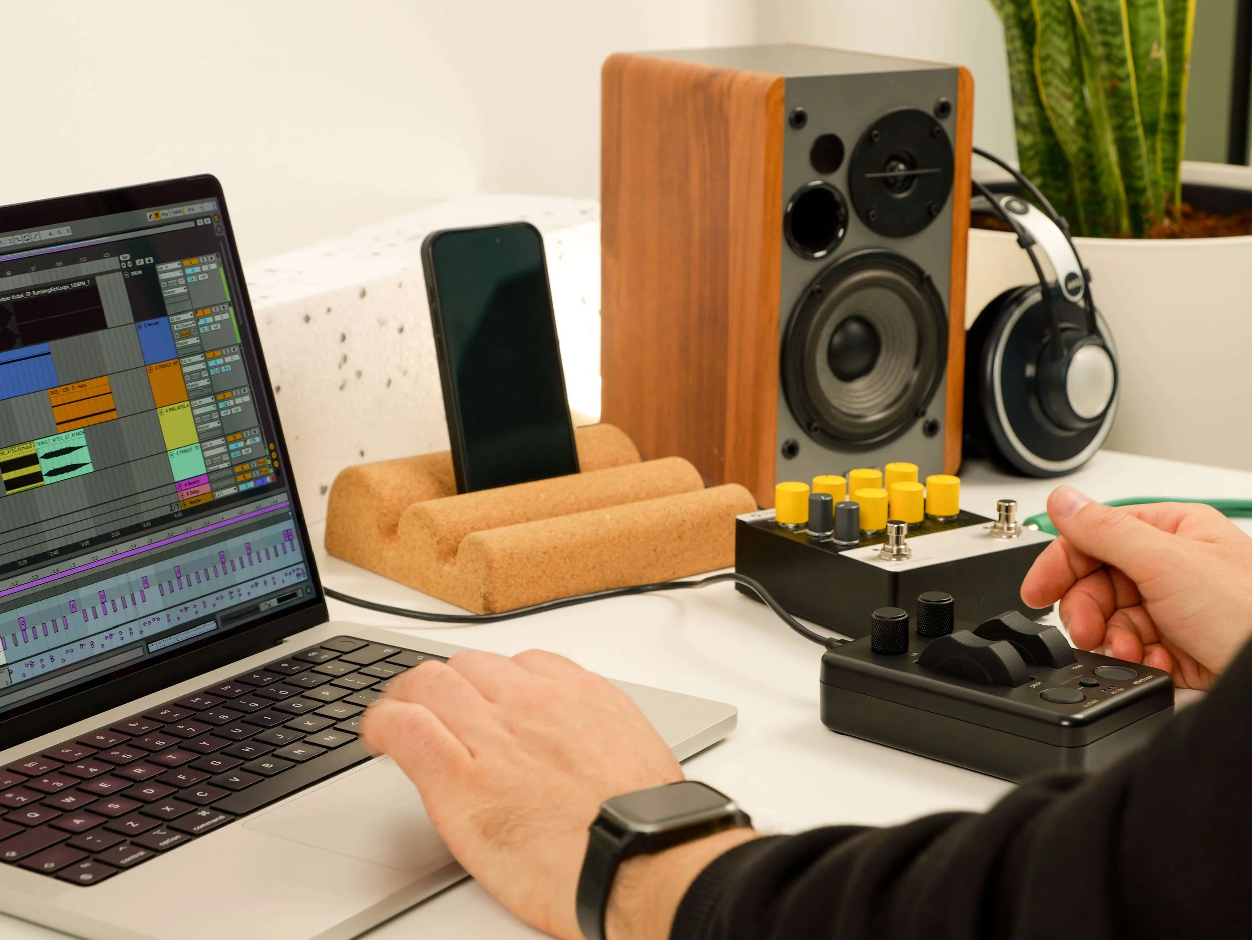 MIDI controller with MIDI surface and mixer next to laptop and compressor in studio setting