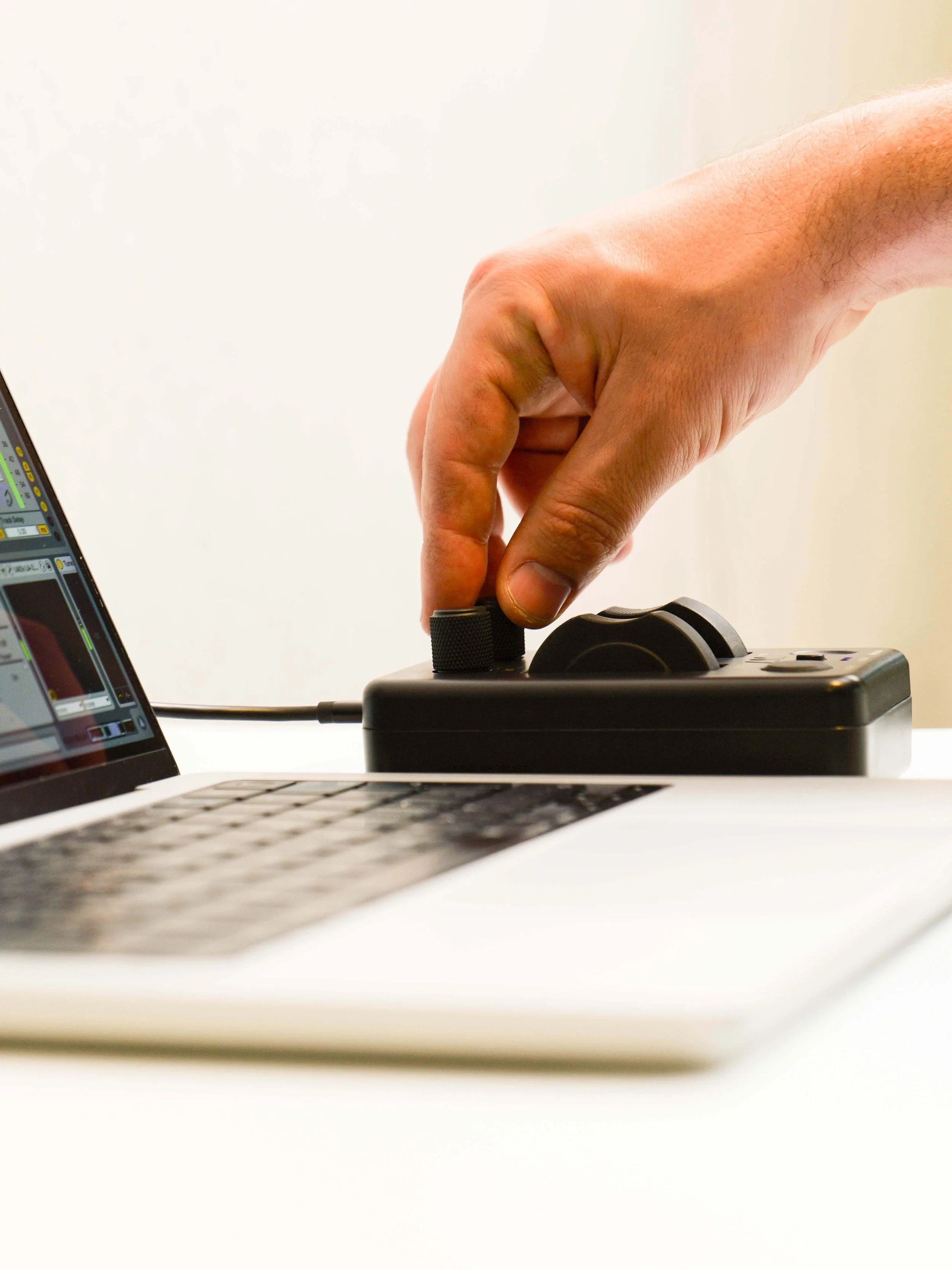 Custom gnurled surface on the knobs of the AM components MOD POD controller in action next to a macbook laptop