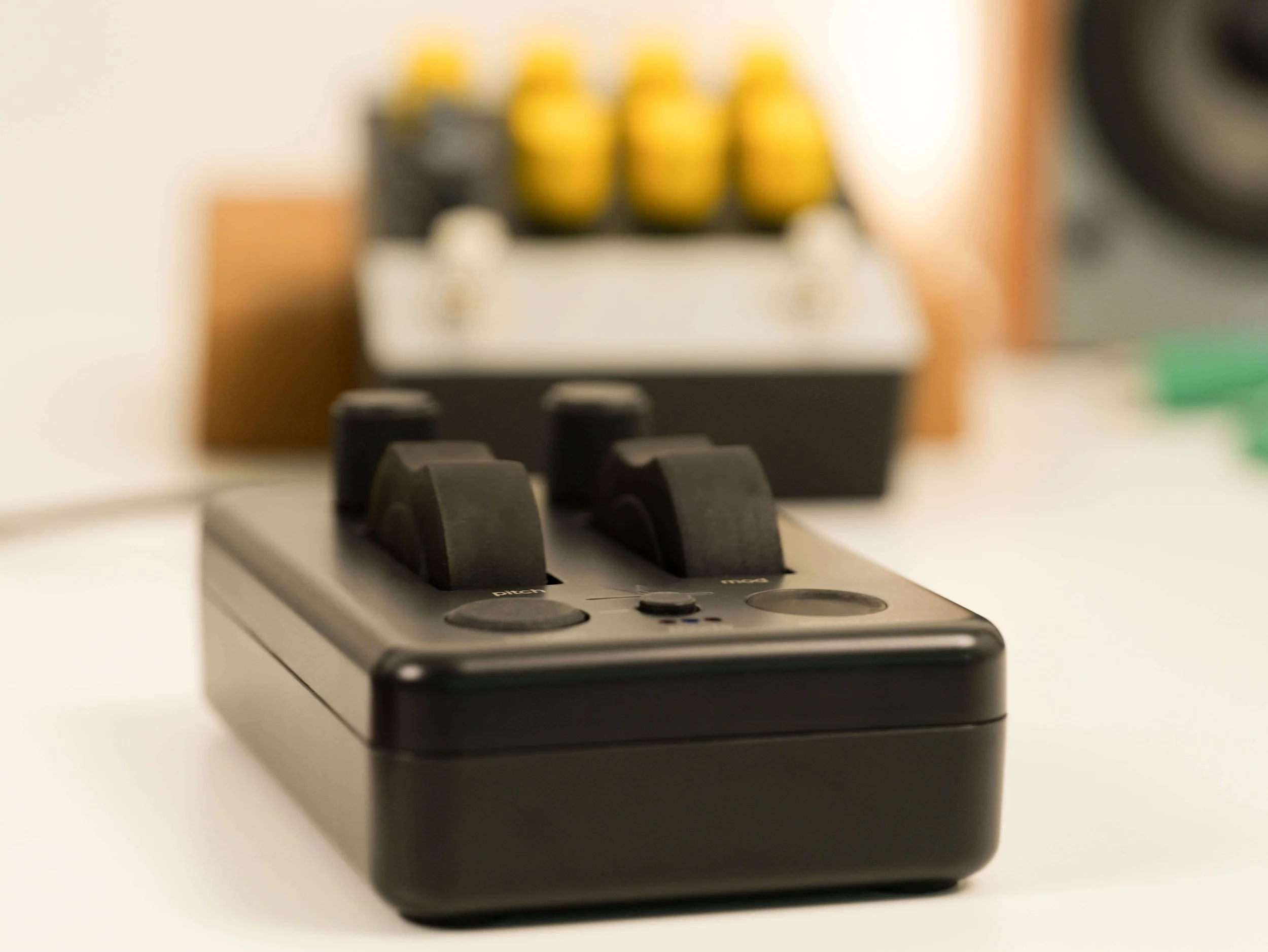 close up view of the MODPOD controller with jog wheels, touch sensitive pads and knobs on display next to a compressor