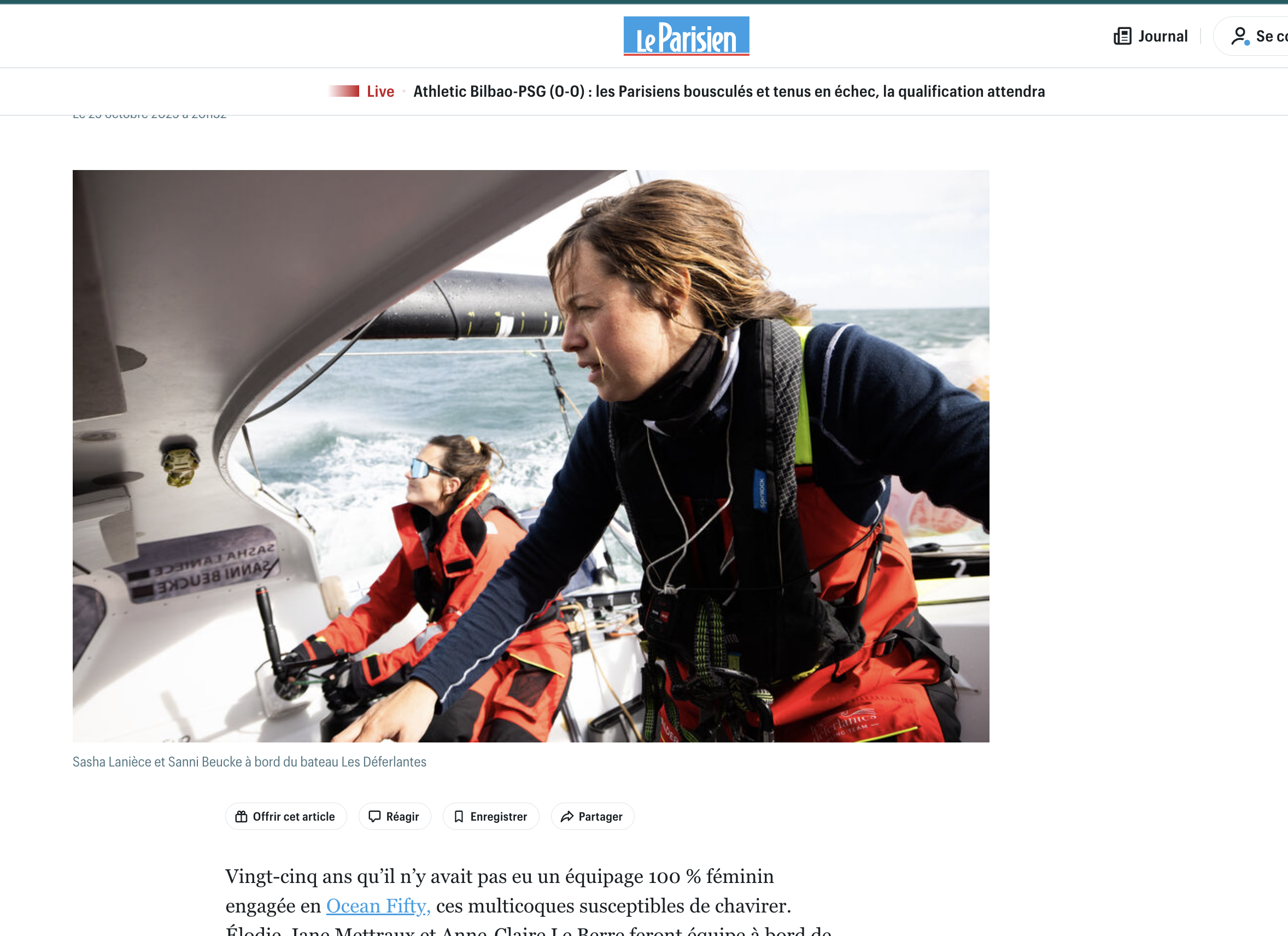Deux femmes en tenue de mer naviguant à bord d'un bateau, portant des vestes de vie, avec l'océan en arrière-plan.