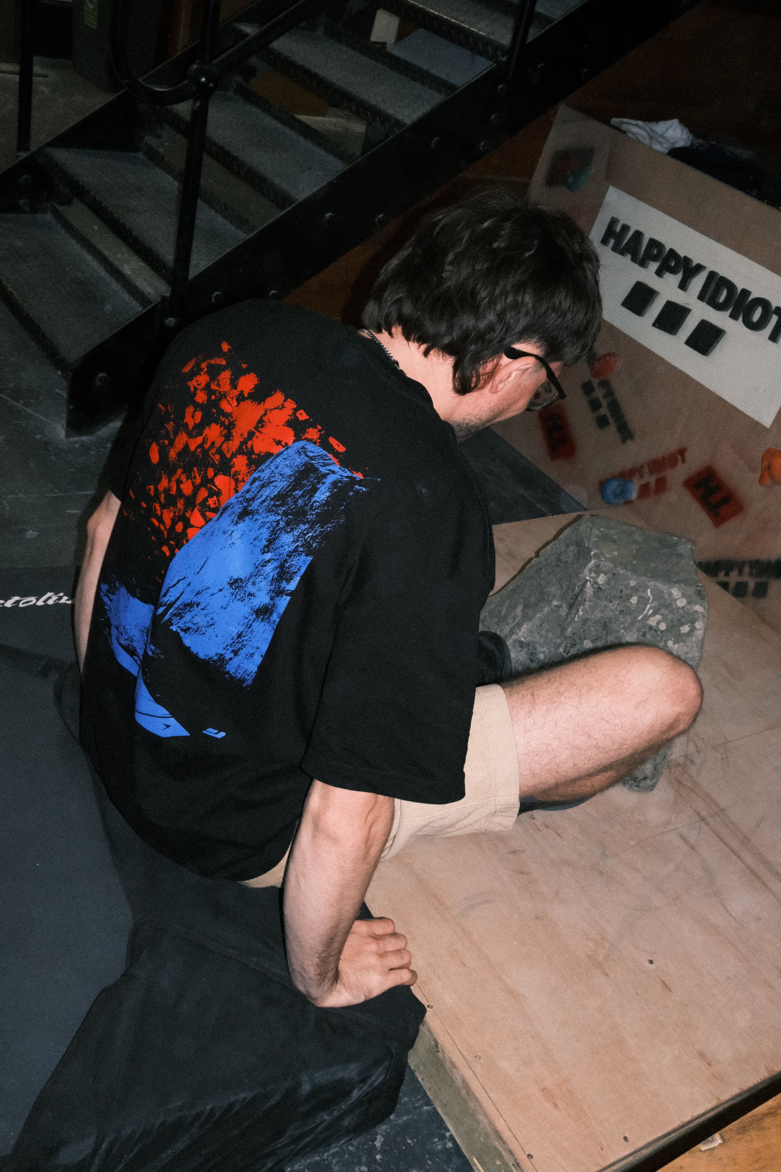 Close-up of the Winter Grit x MADE Contact Point Tee showing its oversized black fit and bold blue and orange graphic back print.