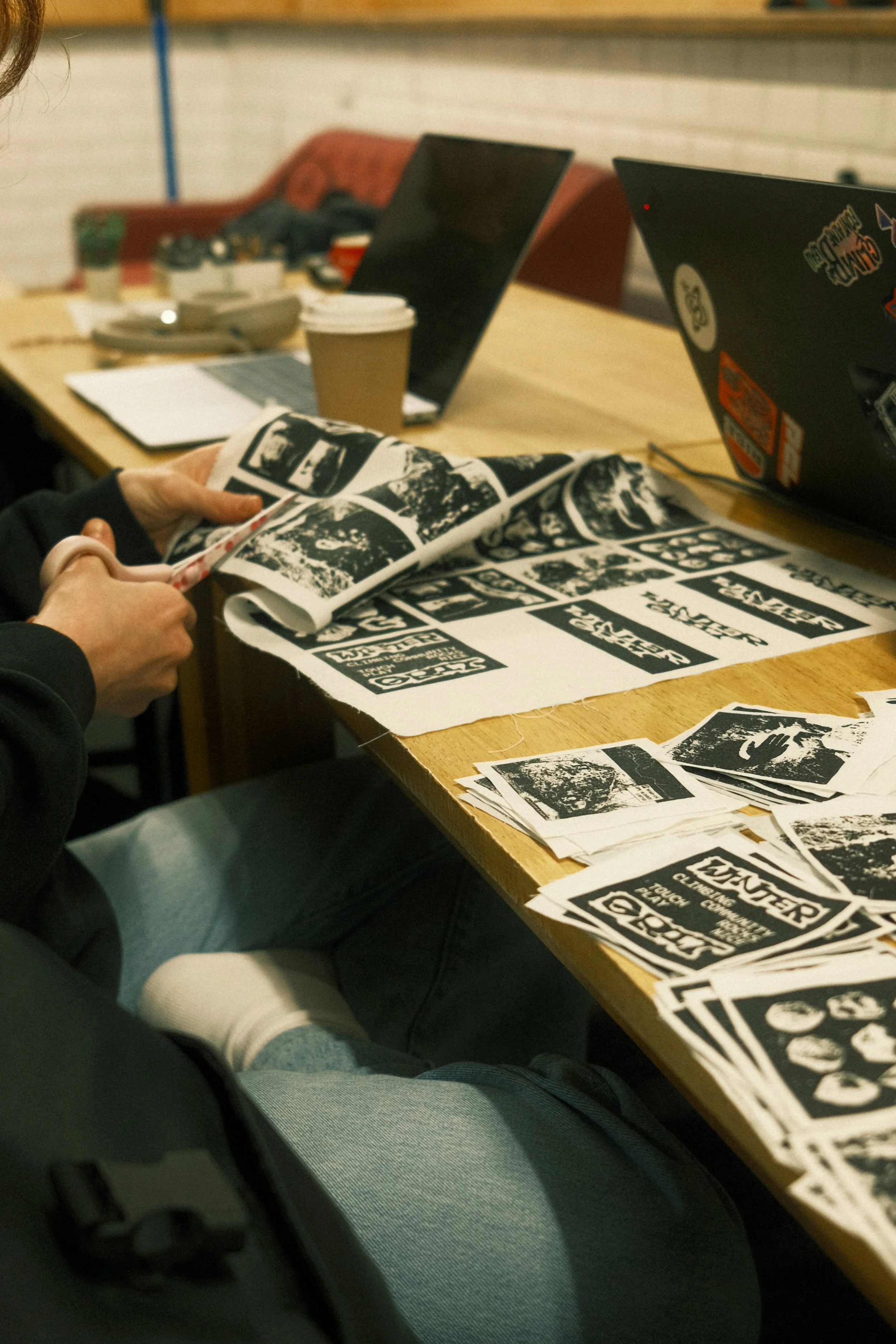 Winter Grit prints and clothing designs laid out on a workbench