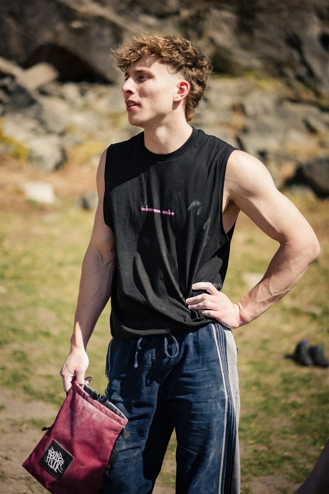 Climber wearing the black Winter Grit men's vest at an outdoor bouldering area
