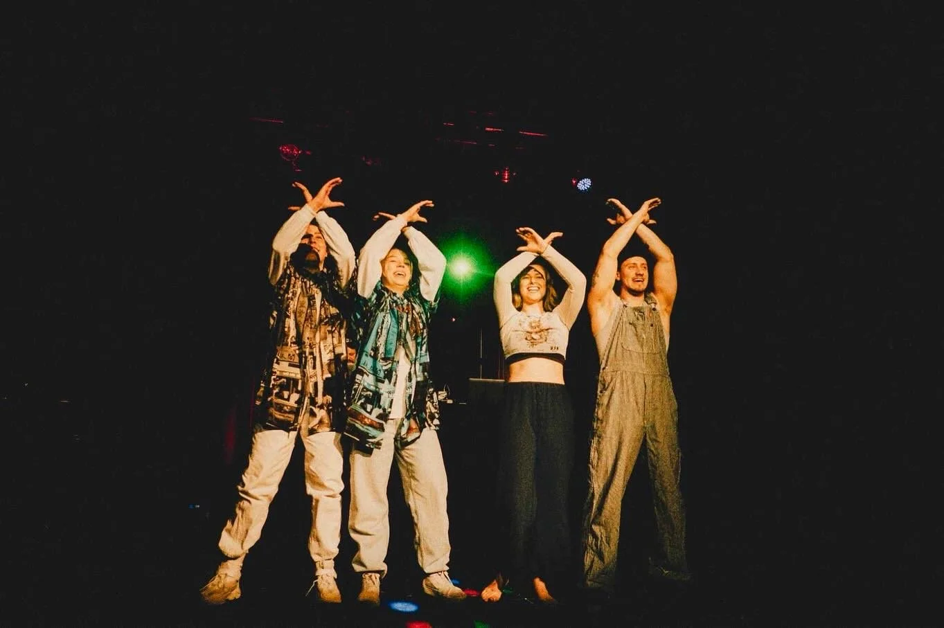 les quatre membre de coppercrib à la fin d'une performance sur scène, les quatre danseurs font le signe de coppercrib avec leurs mains