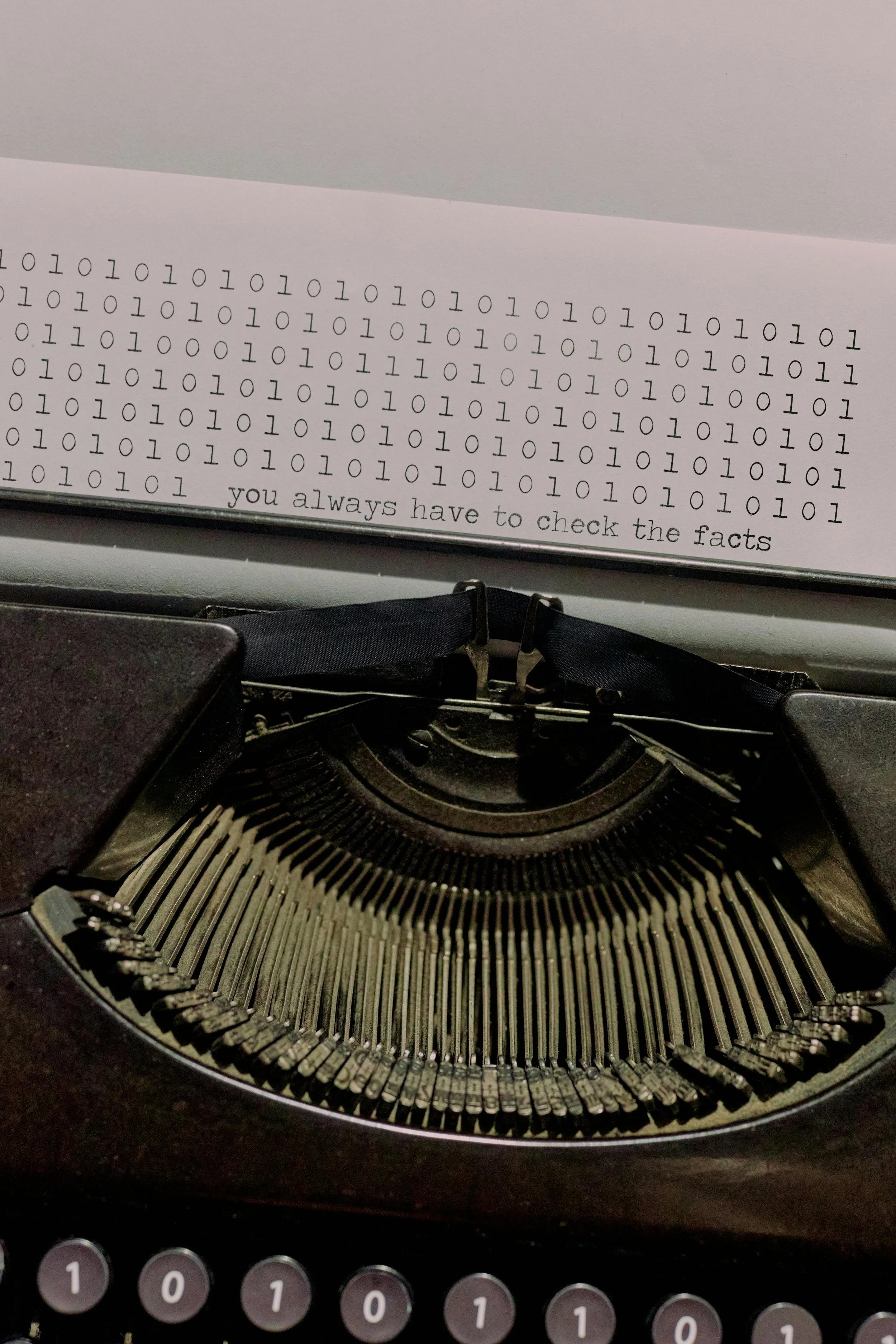 a typewriter with a bunch of zeroes and ones followed by "you always have to check the facts"