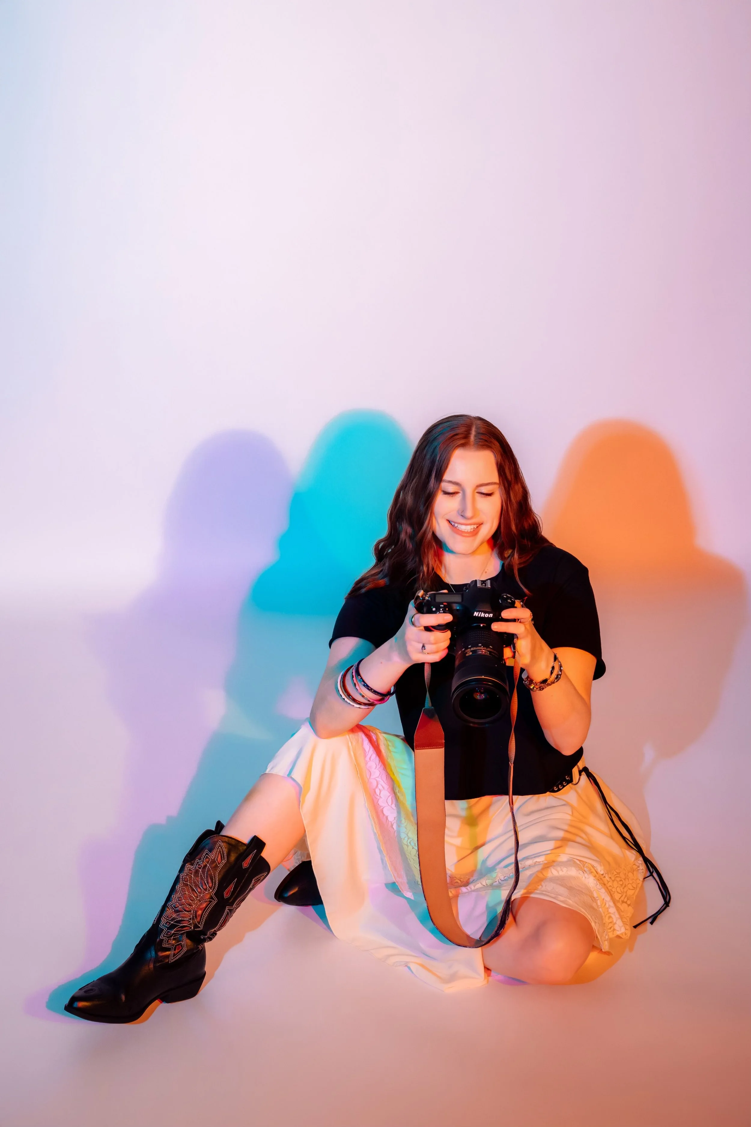 Young woman standing, smiling while wearing a black shirt and jeans.