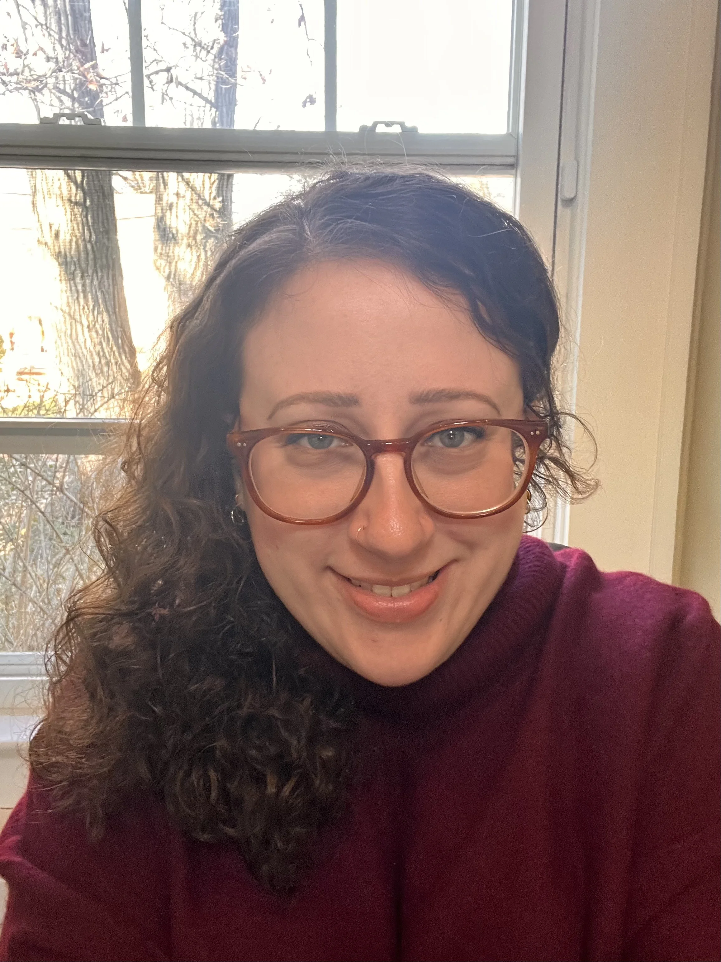 Inclusive therapist, Haley Weissman, smiling with a red sweater in NYC