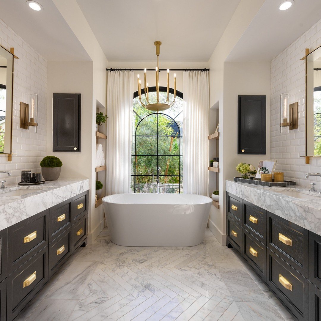 Bubble bath anyone? 🛁This primary bath features a @victoria_albert_baths soaking tub, Restoration Hardware lighting, decorative herringbone marble floors, and an abundance of natural light that create the dreamiest sophisticated sanctuary for gettin