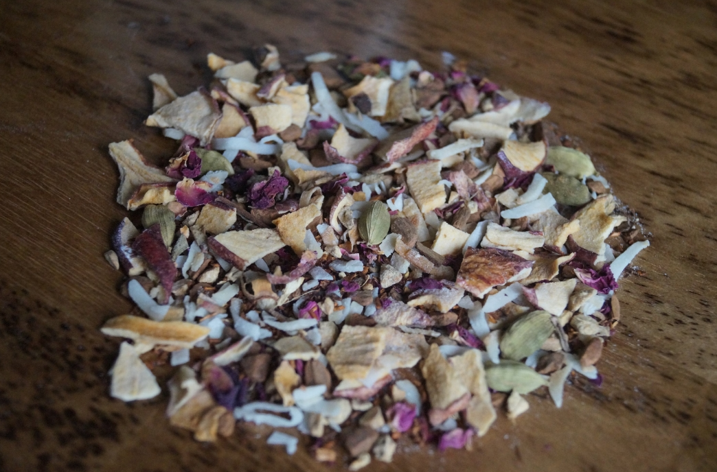 Alpine Punch handcrafted loose leaf rooibos tea made to order with red rooibos, coconut flakes, apple pieces, cinnamon, ginger, vanilla, rose petals, black pepper, and cardamom.
