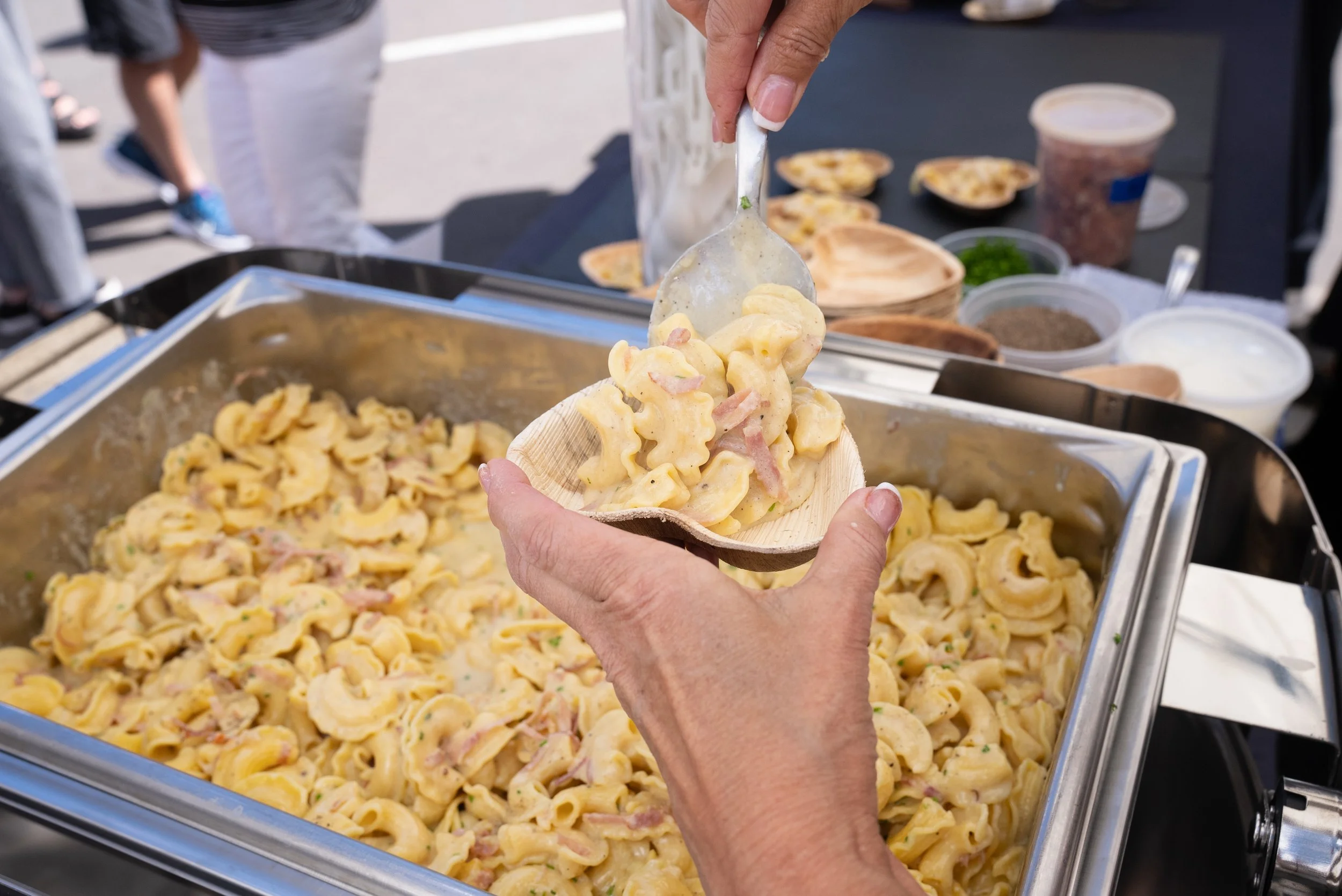 A serving of macaroni and cheese being plated for Aspen Mactoberfest