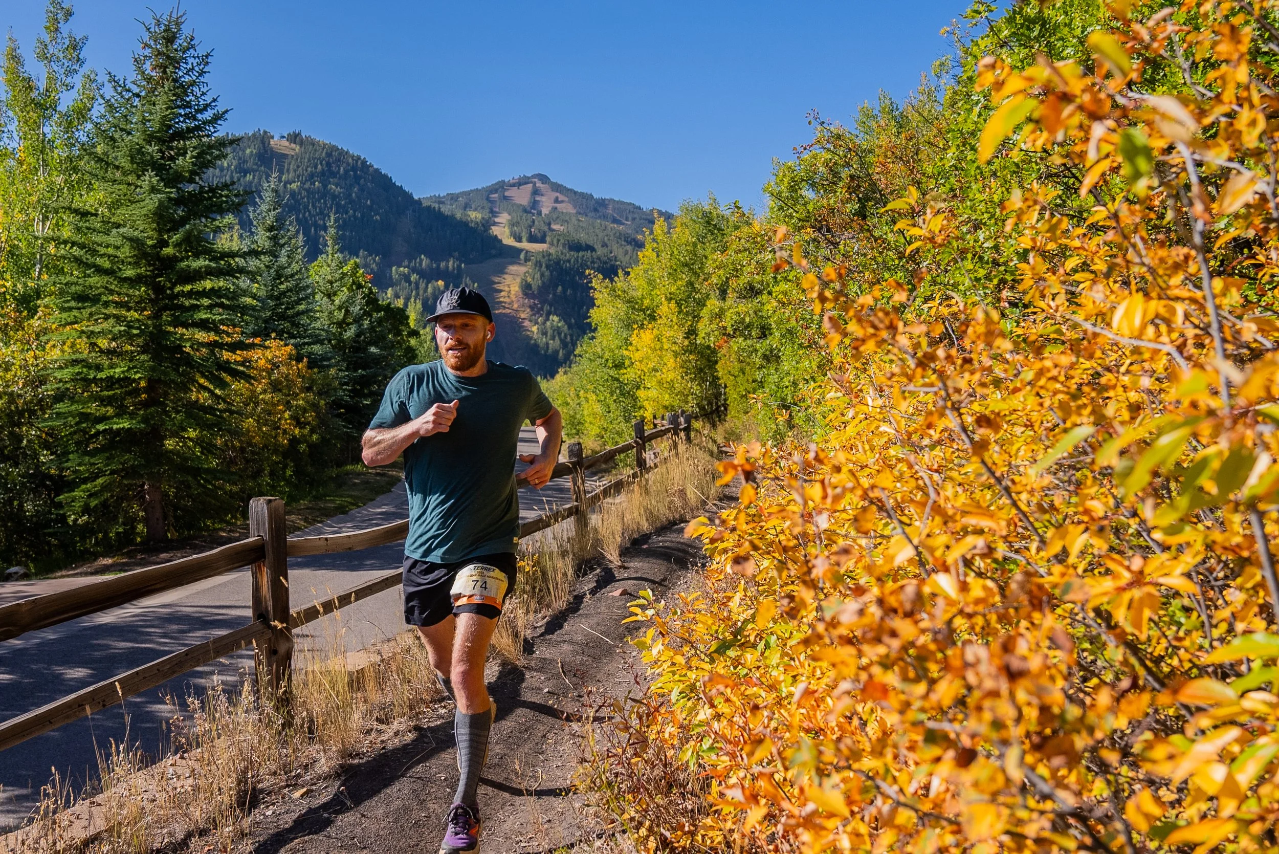 Racer running along a trail with views of mountains in the background