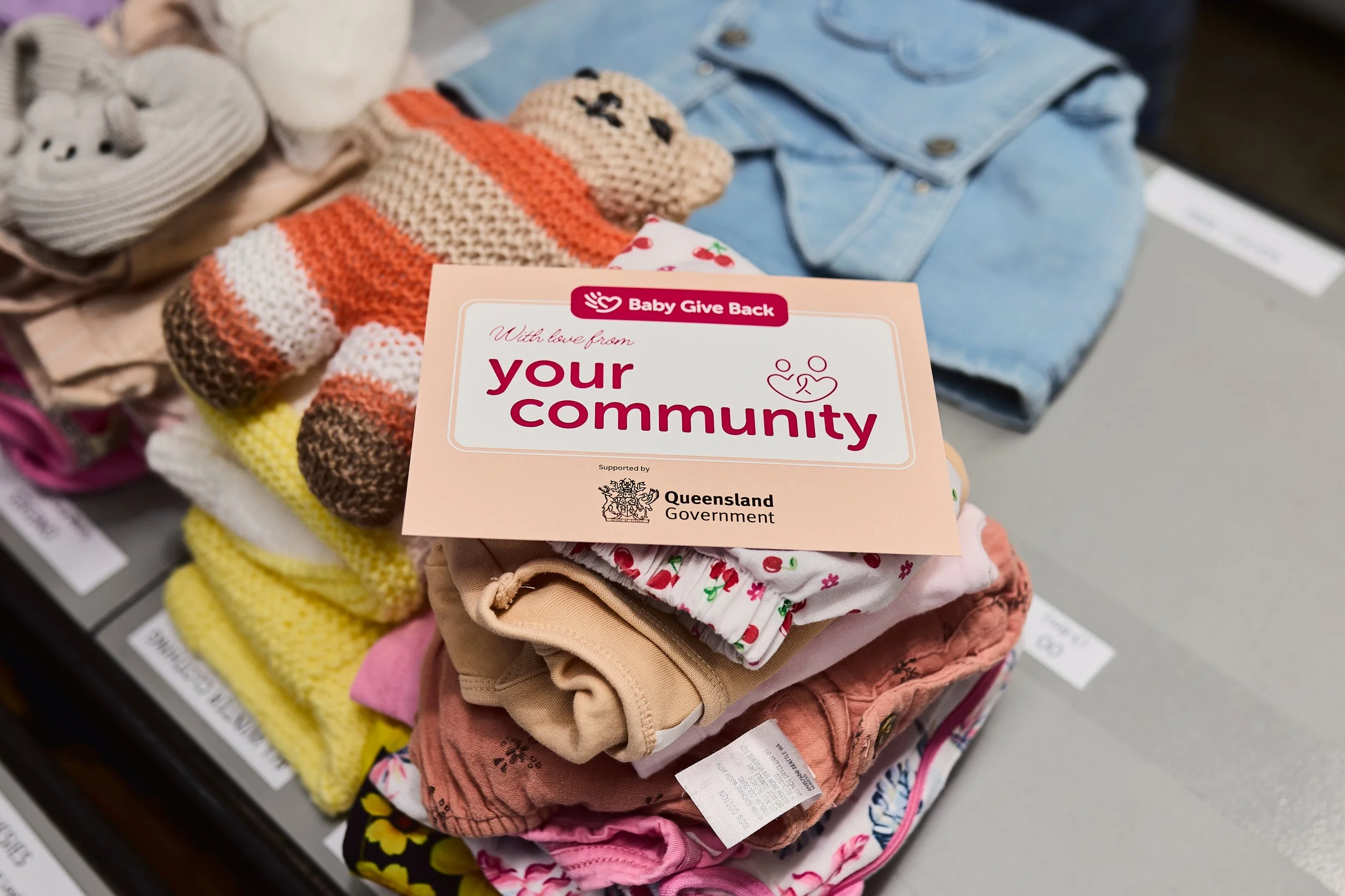pile of neatly folded clothing, toy and community card