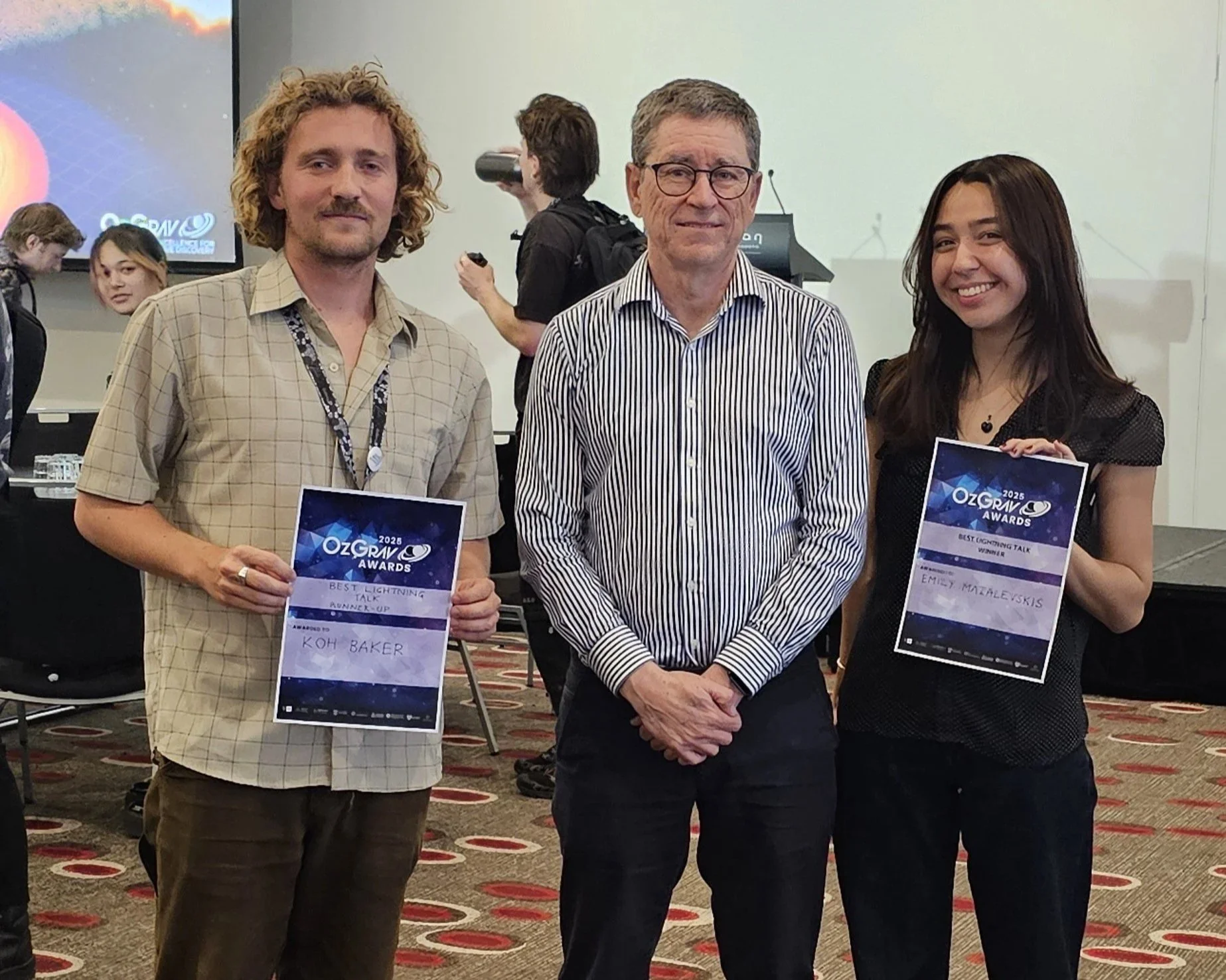 PhD Student Kho Baker and Master Student Emily Mazalevskis recieving best presentation award at the 2025 OzGrav Annual Retreat in Melbourne
