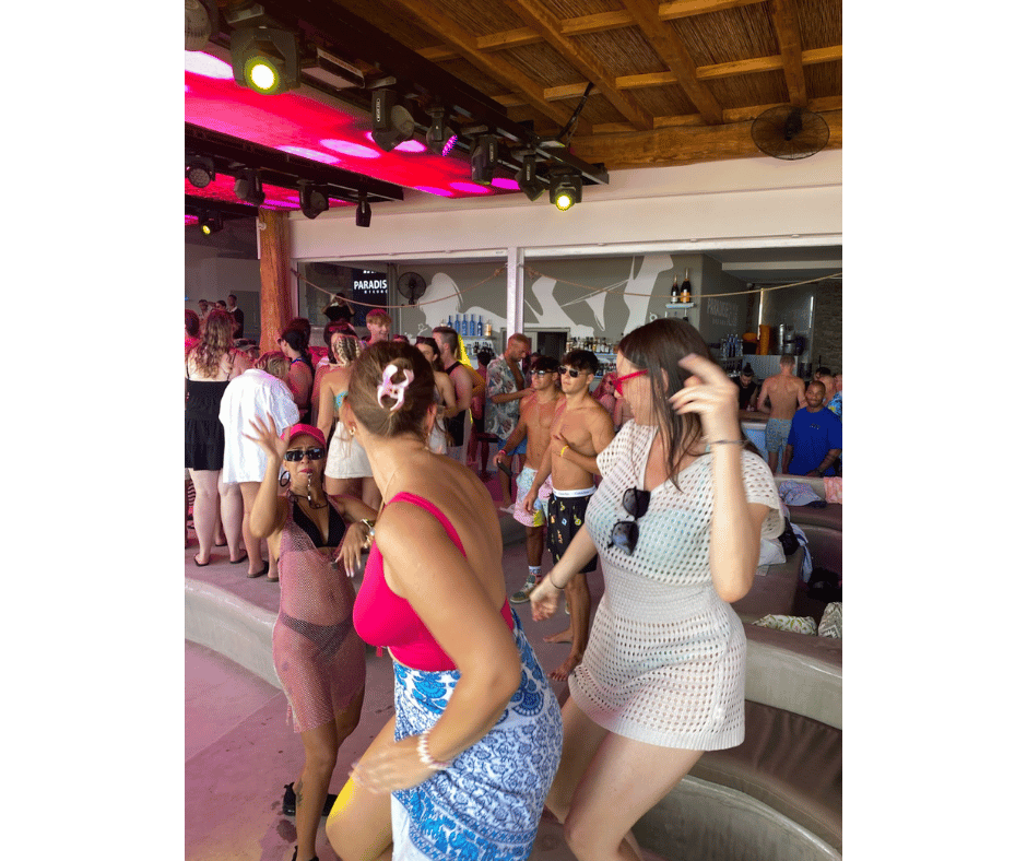 Solo female travellers dancing at a beach club in Ios, capturing the lively and social nightlife that the island is known for.