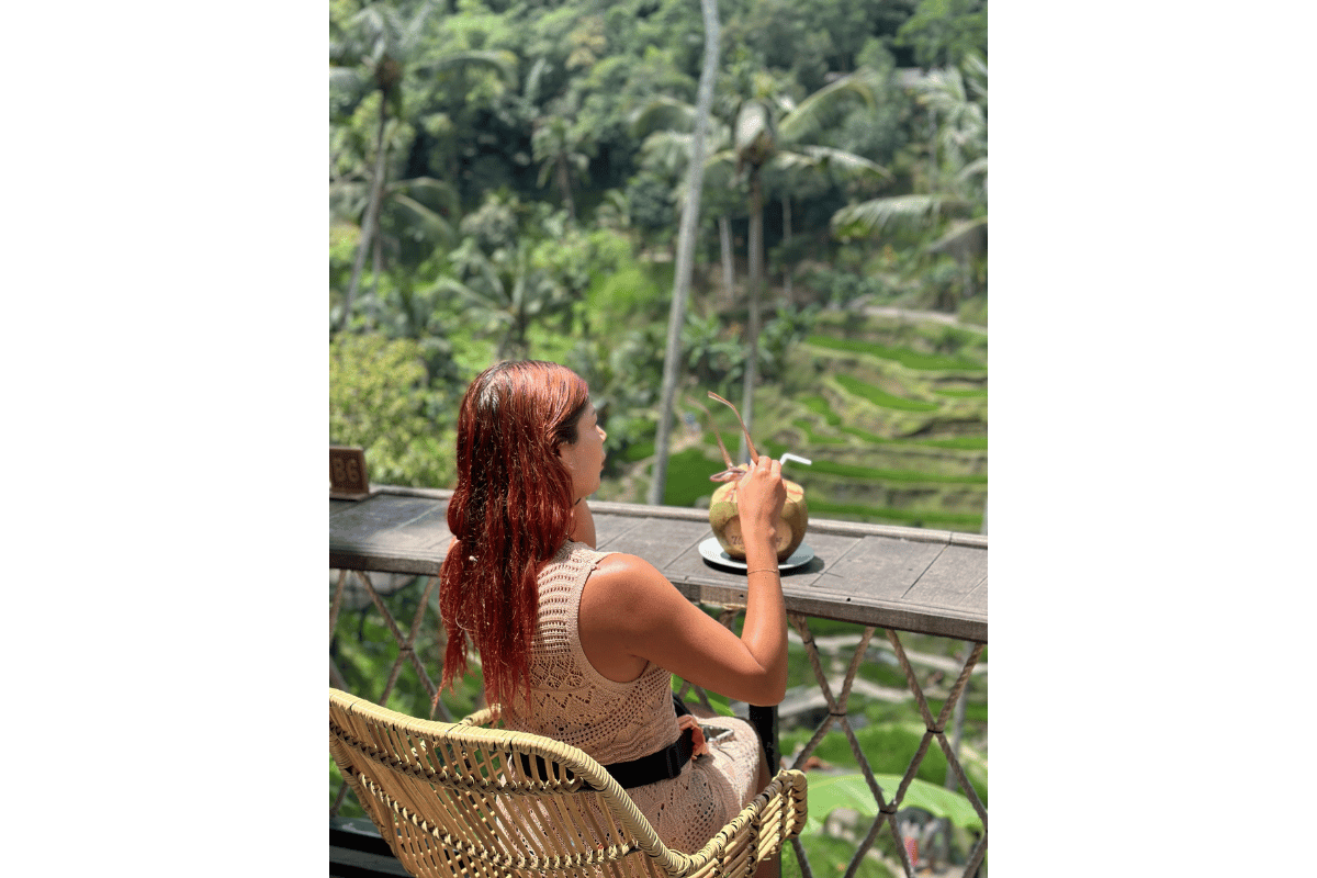 Solo female traveller enjoying a peaceful moment in Bali, surrounded by rice terraces and tropical scenery, representing relaxed and social solo female travel in Indonesia.