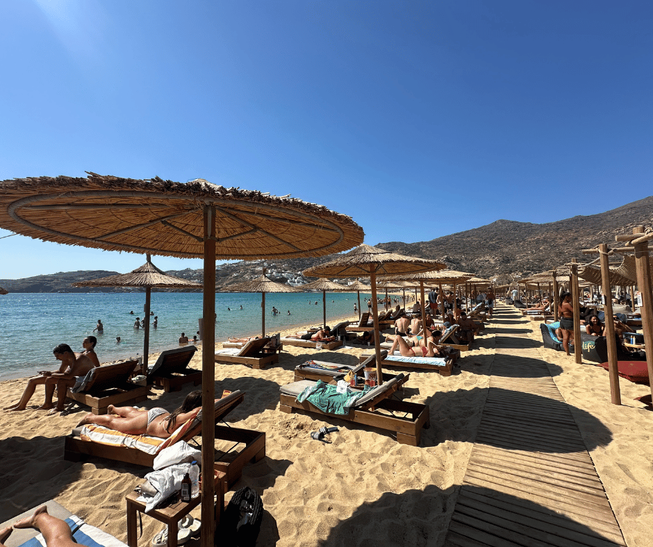 People sunbathing on a Greek beach during a summer trip