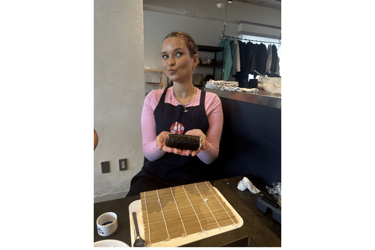 Solo female traveller taking part in a sushi making class in Japan, learning traditional Japanese cooking.