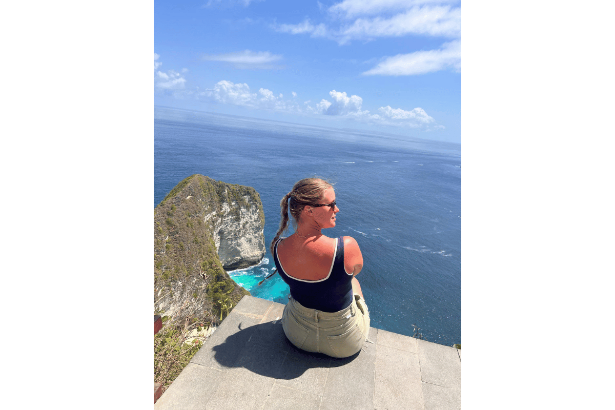 Solo female traveller sitting and overlooking the clear waters of Bali