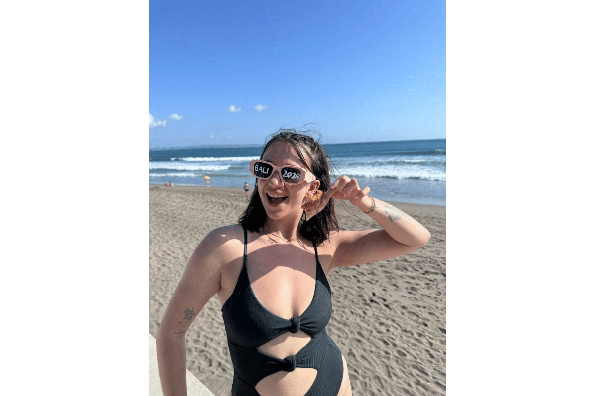 Solo female traveller relaxing at a beach club in Bali, enjoying ocean views and a laid-back afternoon during her Bali trip.