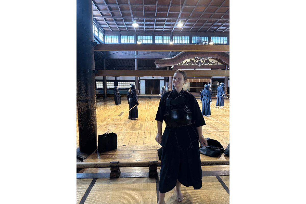 Solo female traveller dressed in traditional samurai-style clothing in Japan, taking part in a cultural experience that highlights respect for history and local customs.