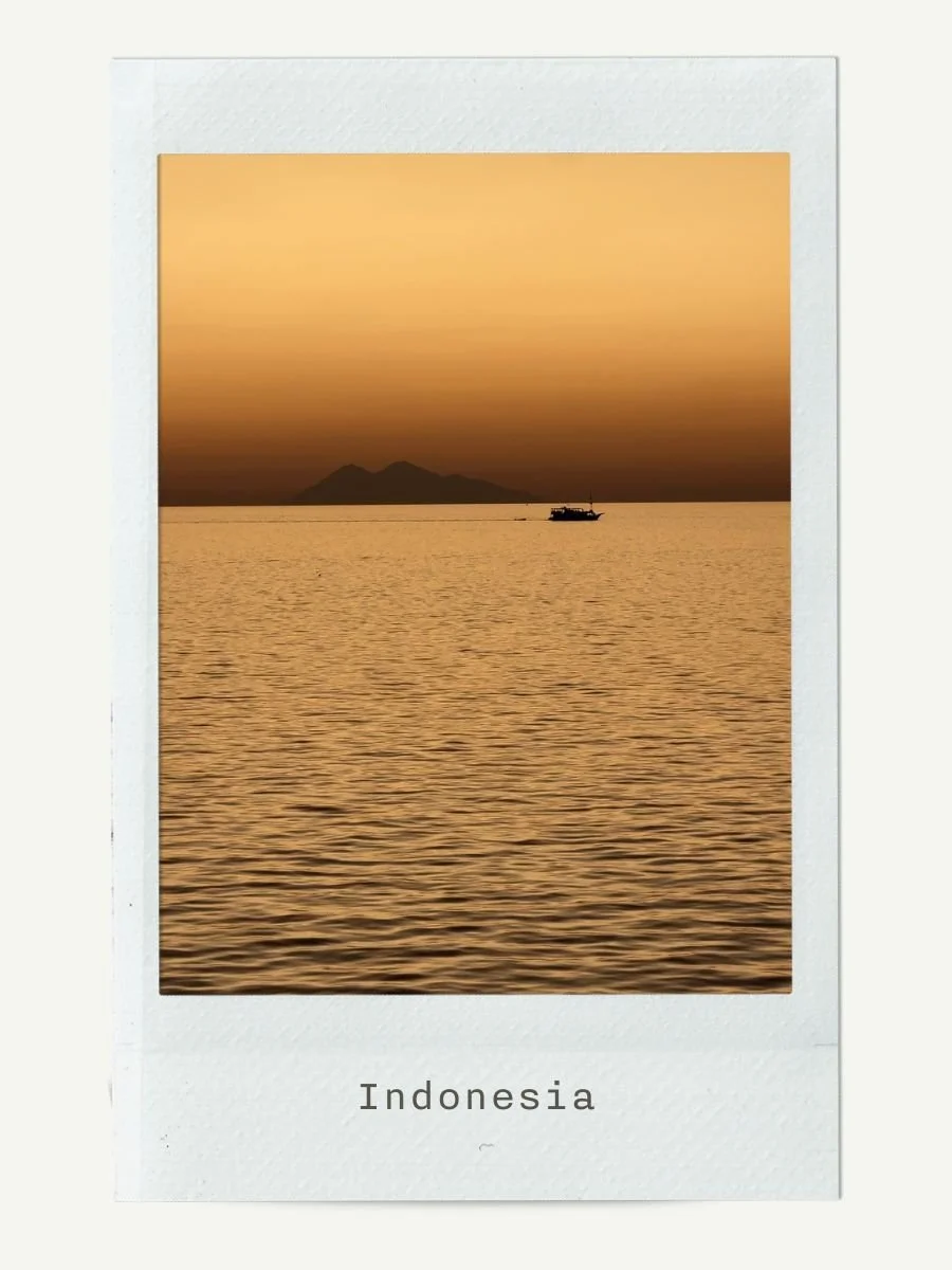 Sunset over the water with a mountain in the background and a boat in the foreground, labeled 'Indonesia' at the bottom.