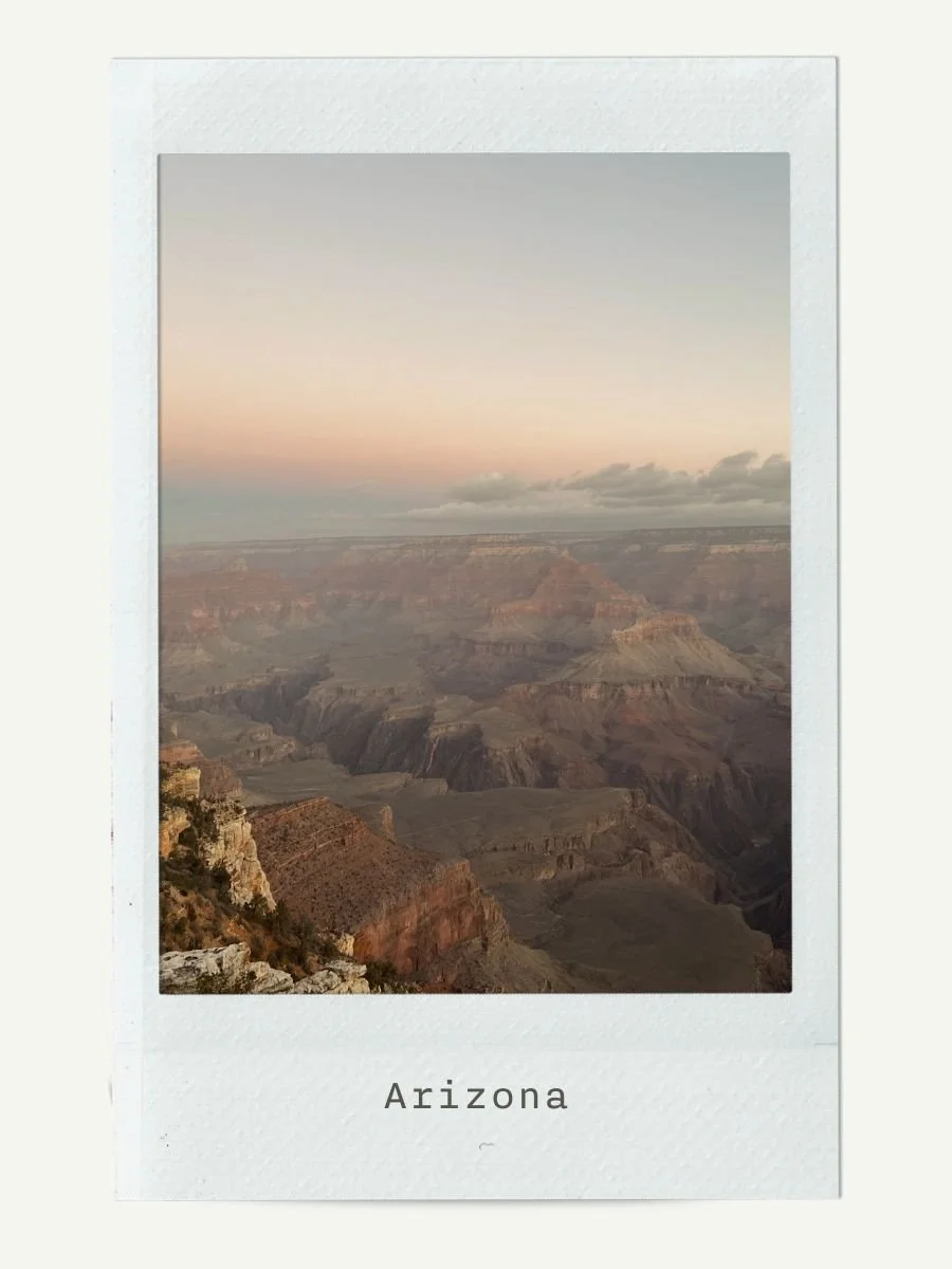 Sunset view of the Grand Canyon in Arizona with layered rock formations and a few clouds in the sky.