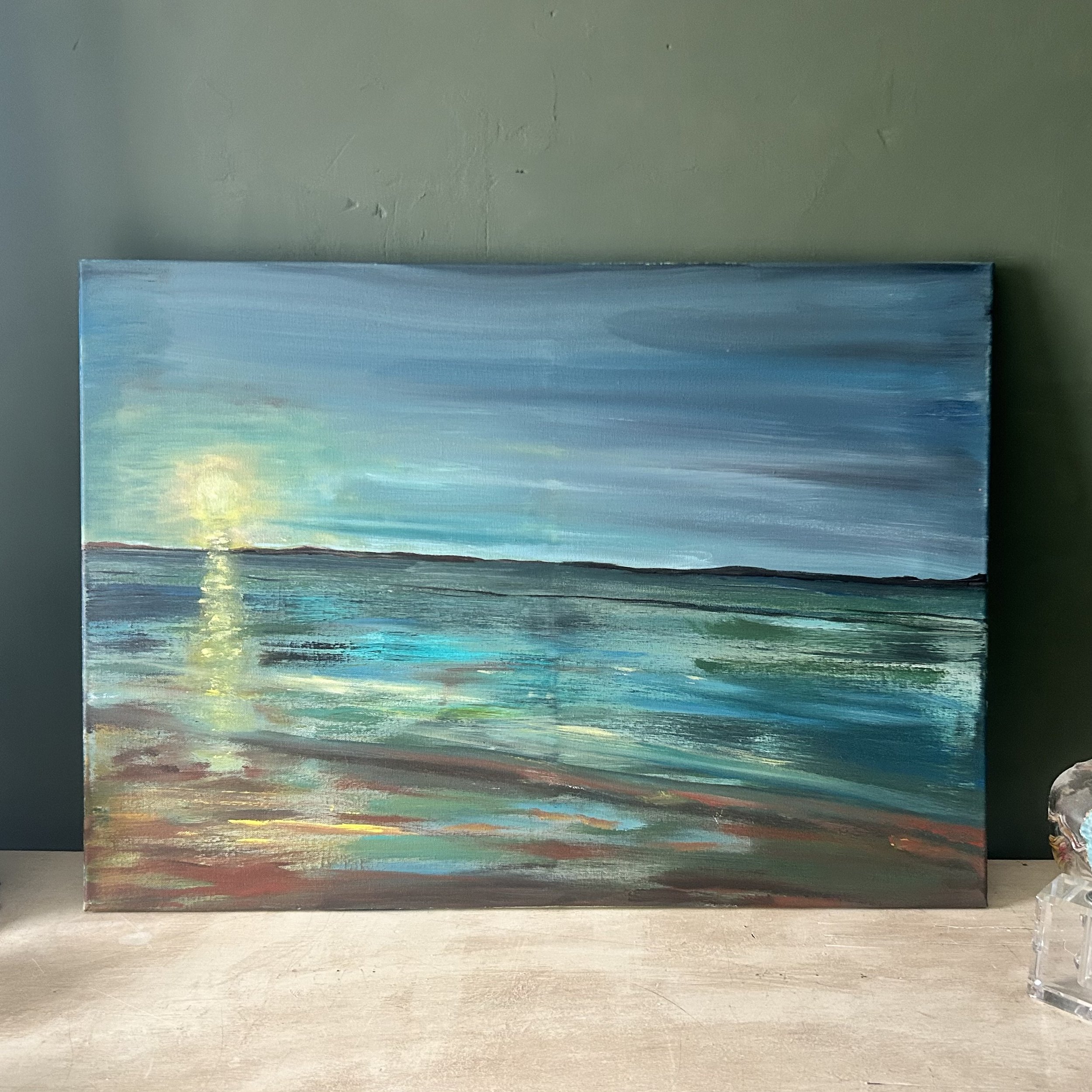 Painting of a serene beach scene with a sunlit horizon, water reflections, and soft colors on canvas.