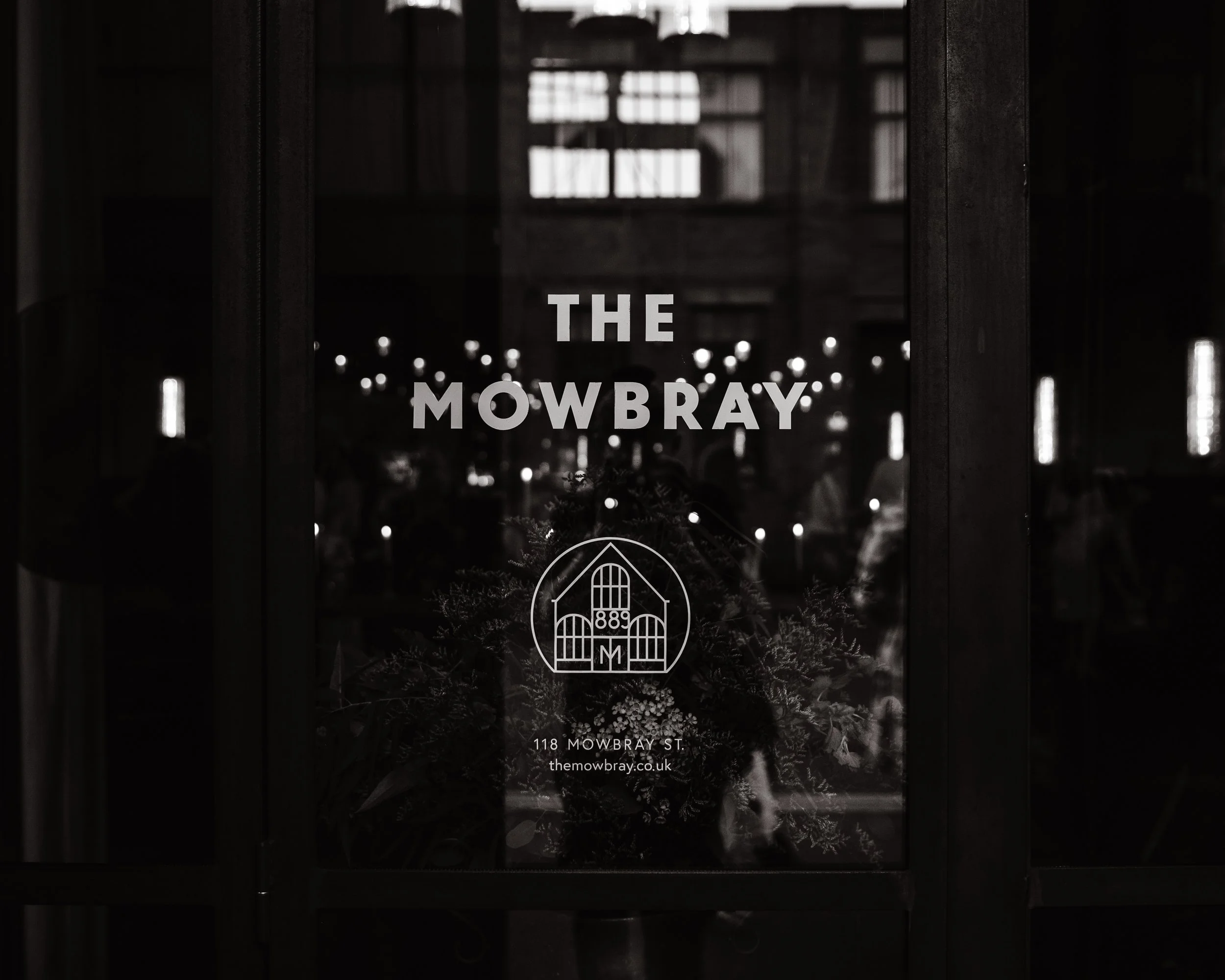 Entrance of The Mowbray with logo and reflections on glass door