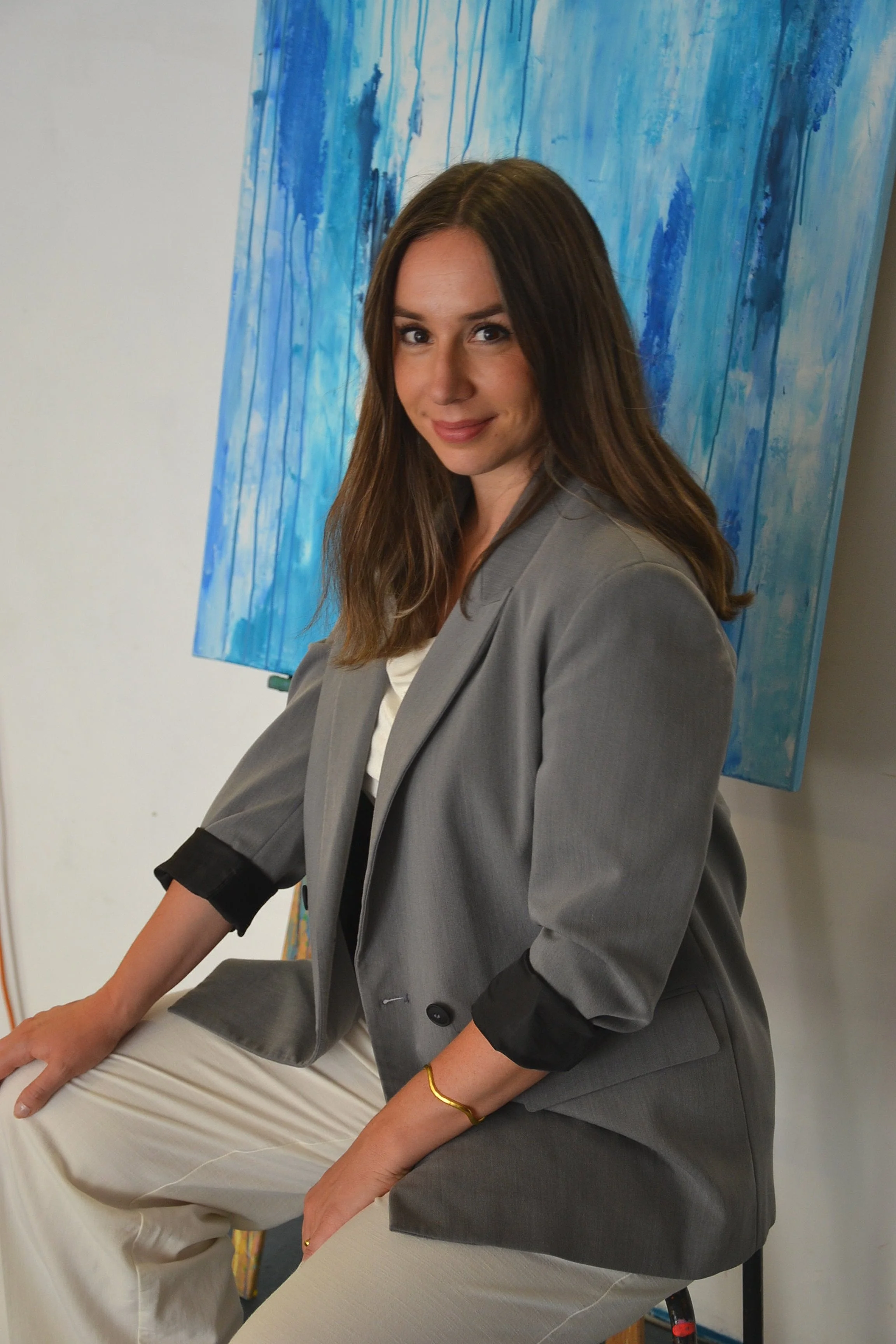 Portrait von Künstlerin vor blauem abstraktem Bild