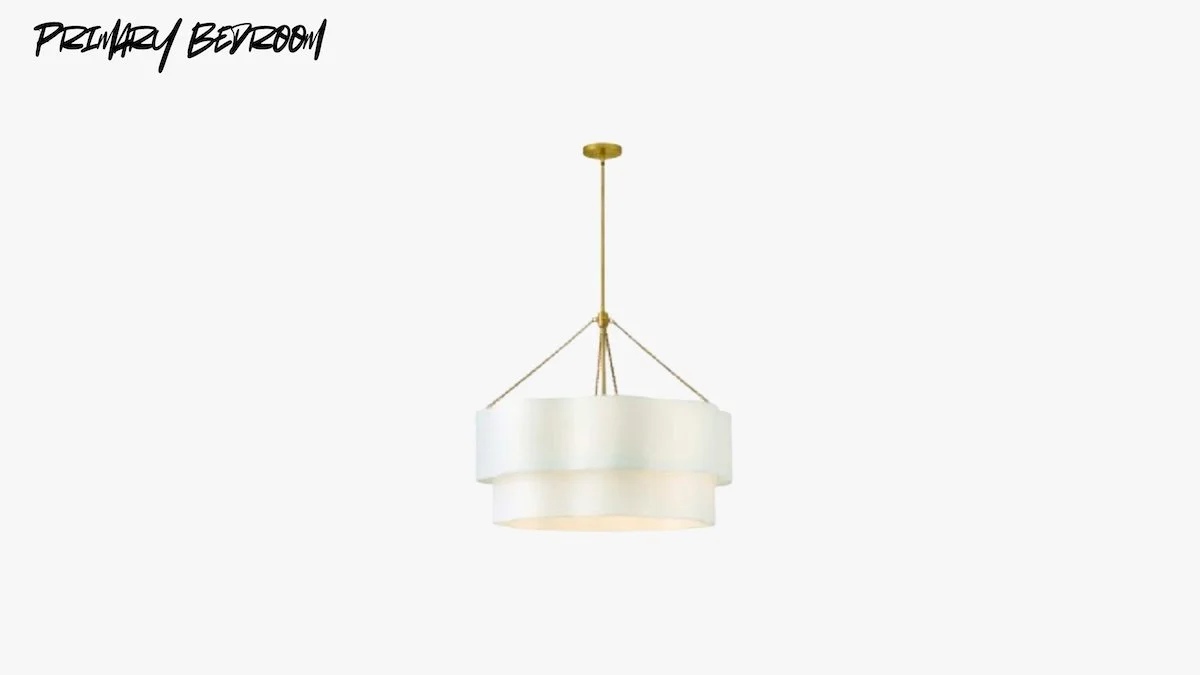 A modern white pendant light hanging from a gold ceiling mount in a primary bedroom.