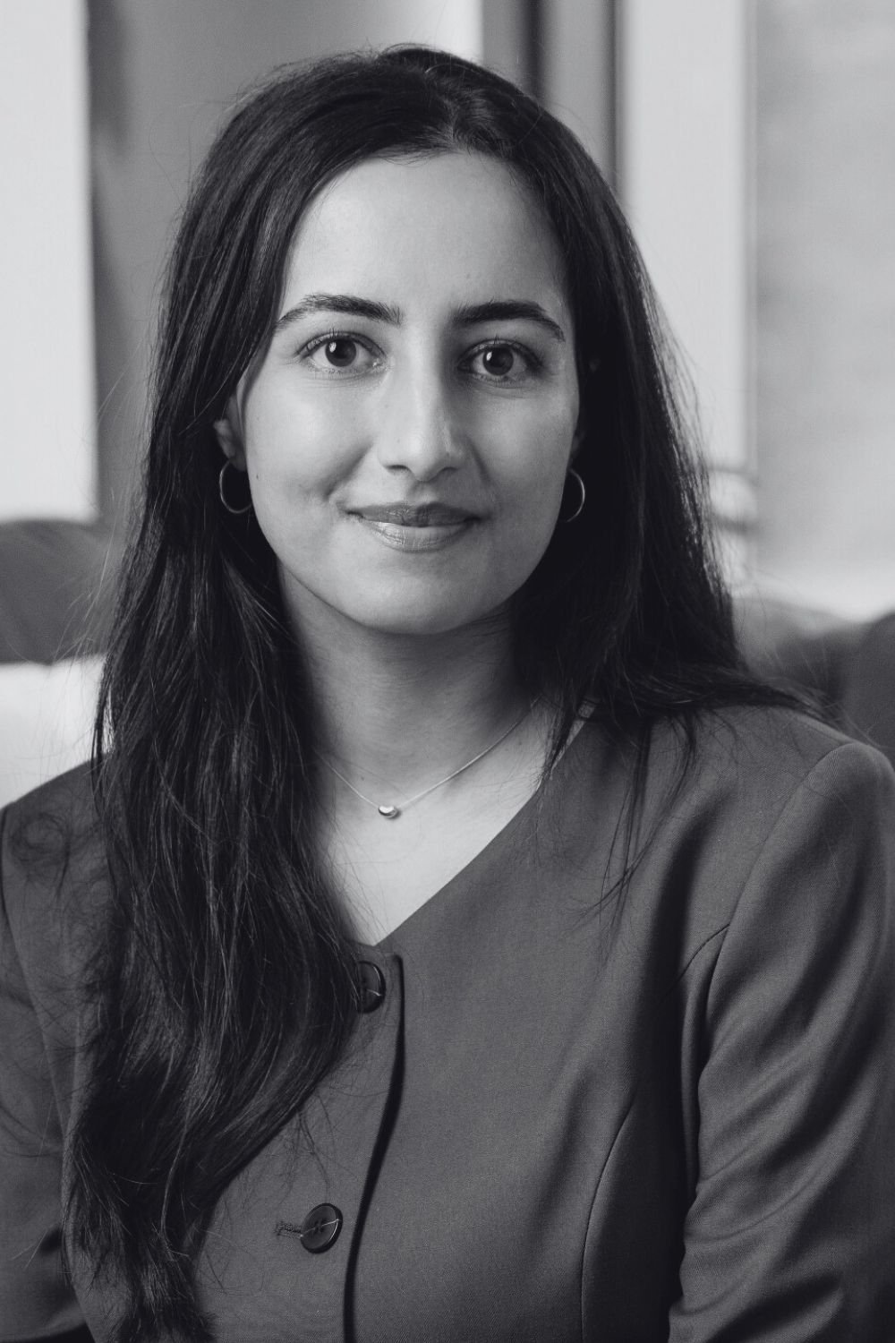 Woman smiling with long dark hair in office attire. Legal assistant at CFT