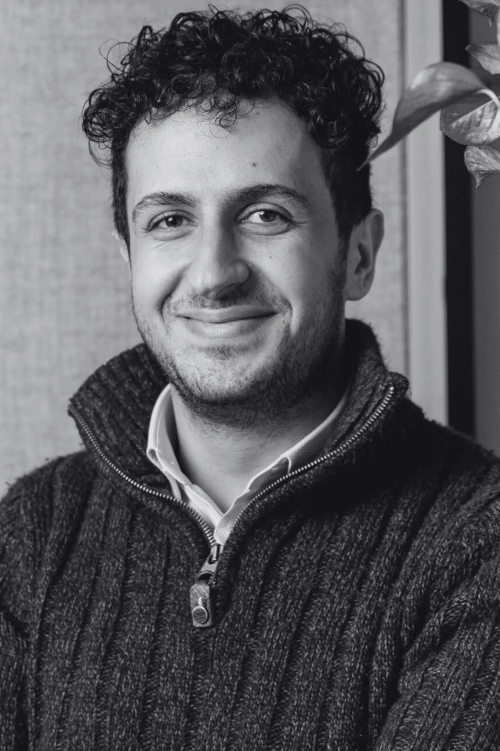 Portrait of Josh, a young man smiling outdoors, wearing a dark fleece jacket with 'Cambridge Future Tech' embroidered on it.