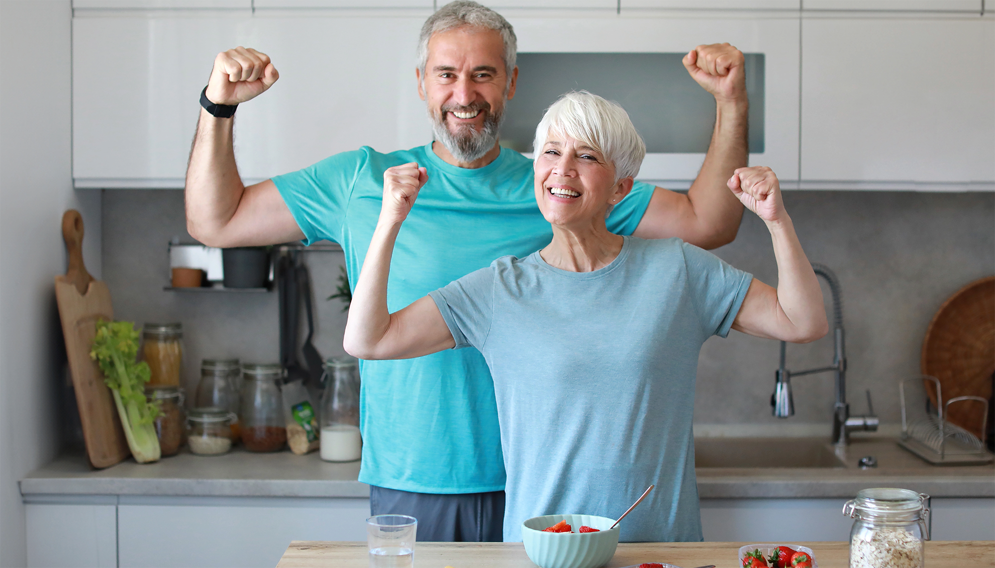 two adults showing their muscles