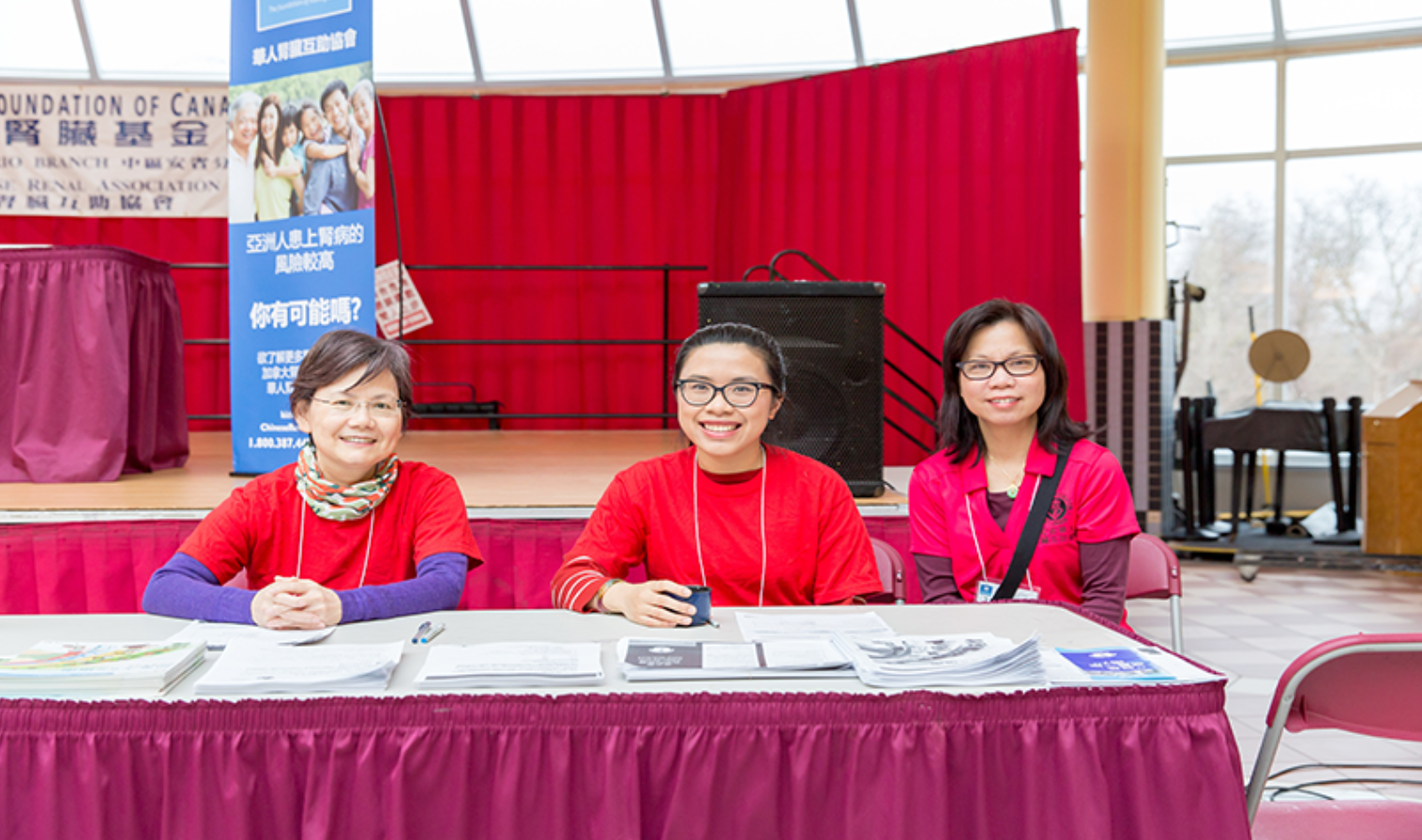 Three ladies at a booth smiling