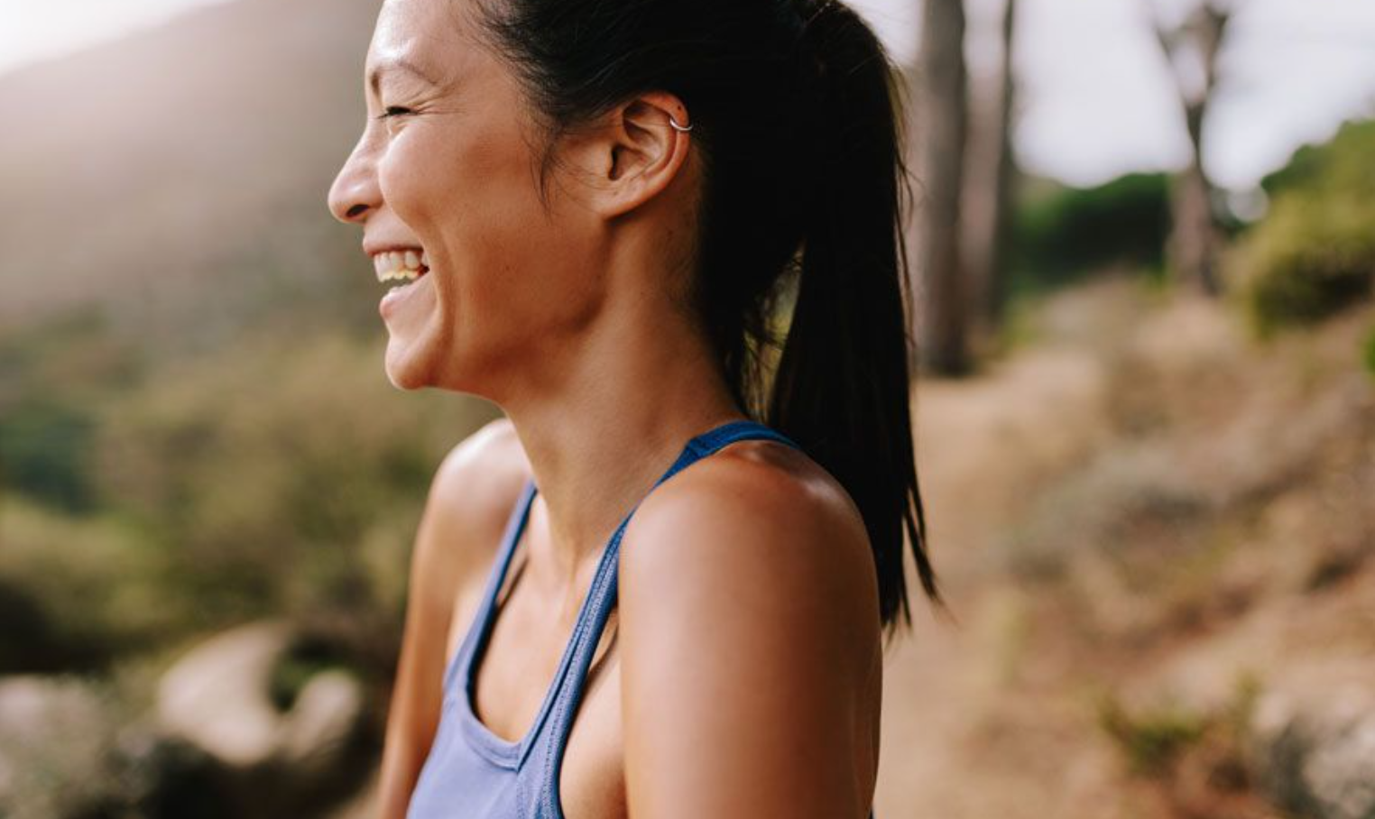 A lady laughing while on a hike