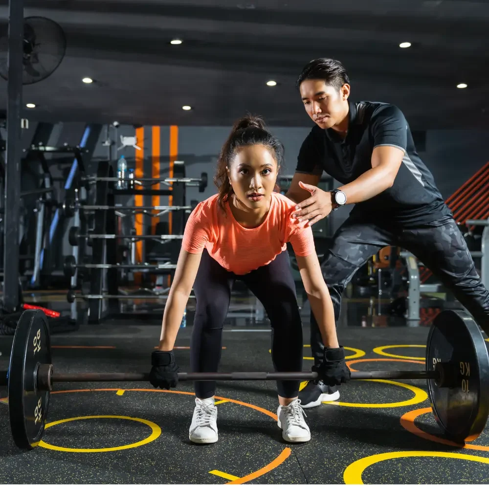 personal trainer teaching weights beginner