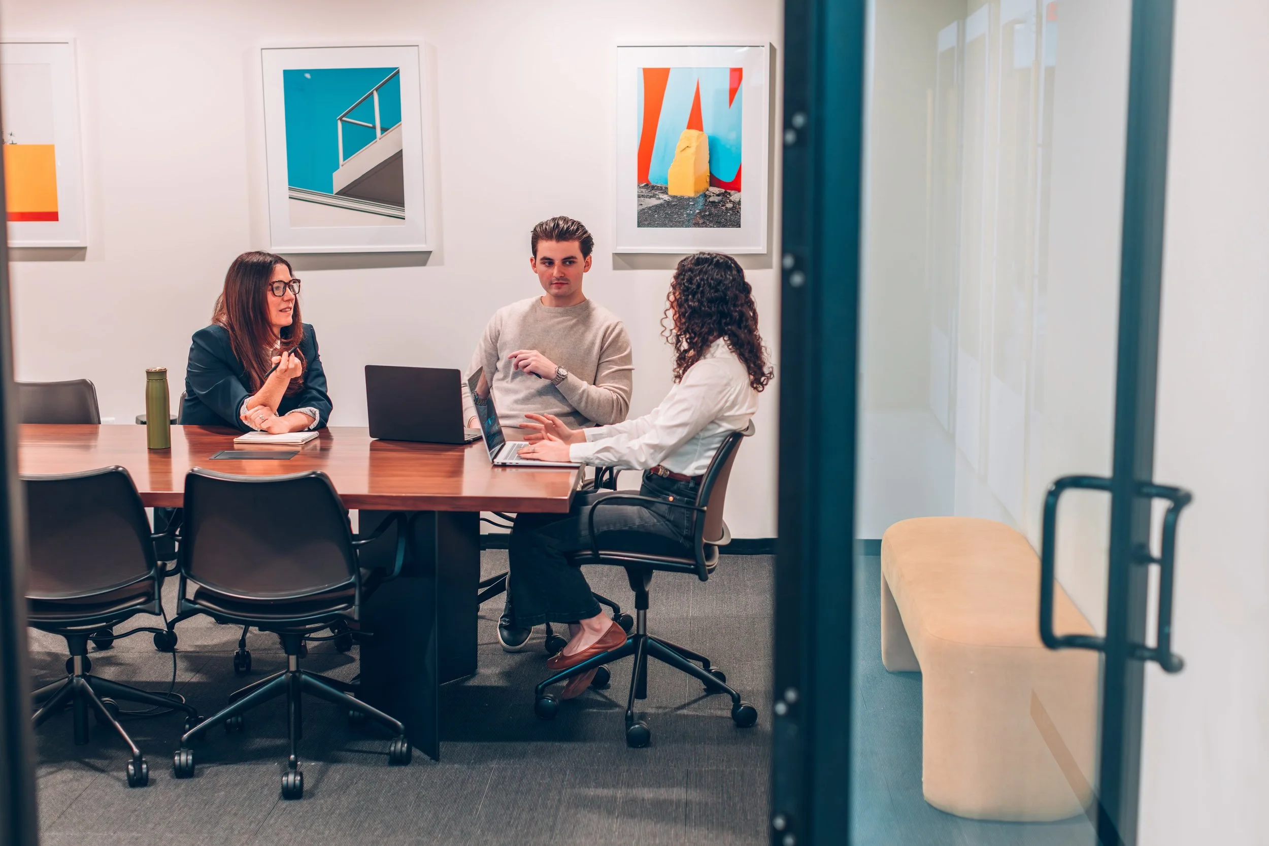 Michele, Carley, and Harry of O’Leary Group in discussion in a conference room.