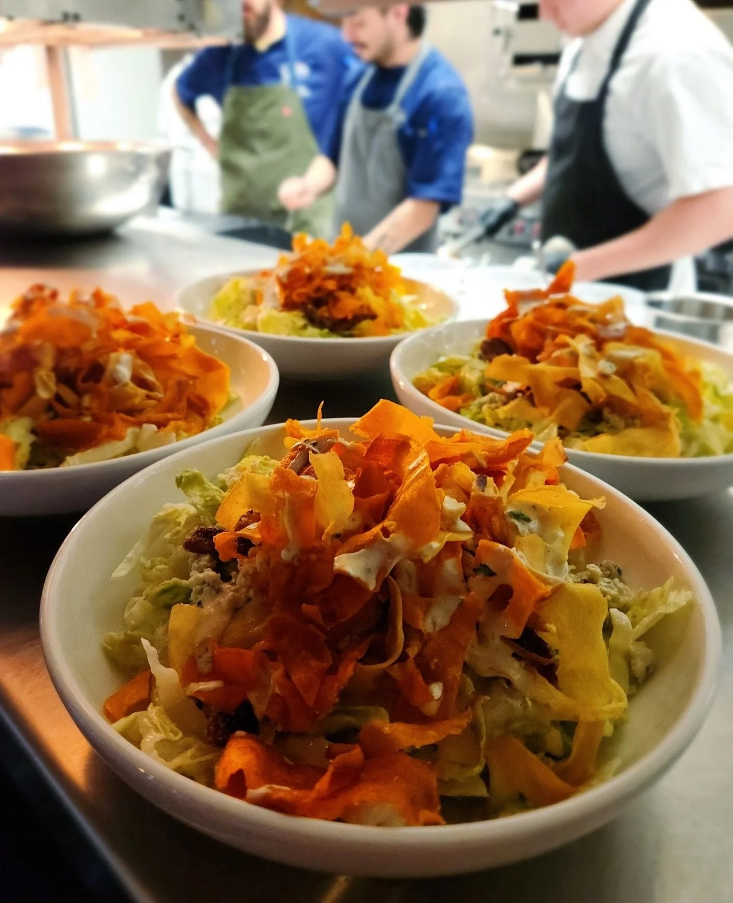 The Blue Ribbon Salad is one of our most popular dishes for a reason; just look at how gorgeous it is! Made with ribbons of iceberg and romaine lettuce, crumbled bleu cheese, candied pecans, and veggie crisps, all topped with a white peach vinaigrett