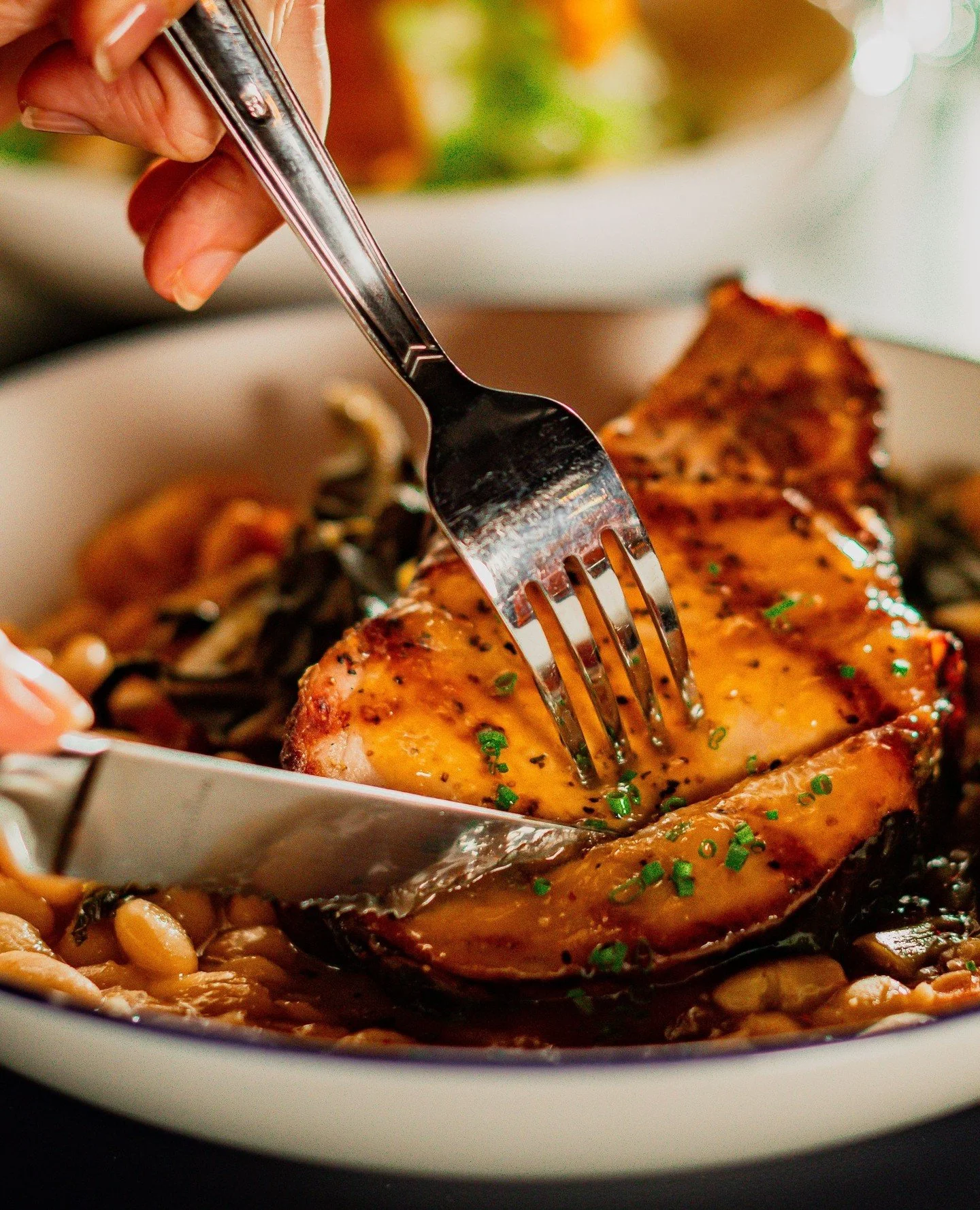 Our hickory-smoked and grilled pork chop is a crowd favorite! Topped with a chili peach glaze and served with white beans and collards, this southern classic is a meal you'll never forget!⁠
⁠
📸: @drewmaynard⁠
⁠
#factoryatfranklin #finediningfranklin